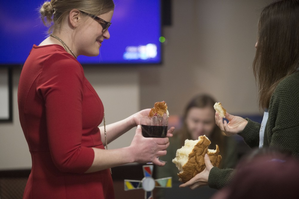 Rev. Lauren Rheingans, campus minister for the Wesley Foundation, receives communion during a weekly worship service in Coffman Union on Sunday, March 10.