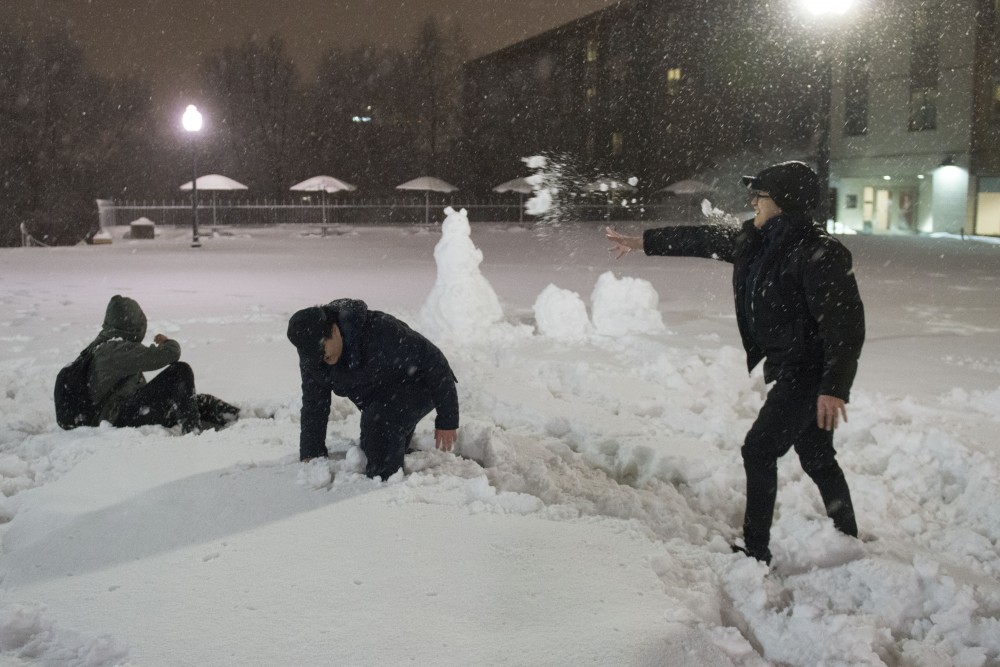 Vinh Nguyen, Tam Nguyen and Long Nguyen throw snowballs on Saturday, March 9 on campus.
