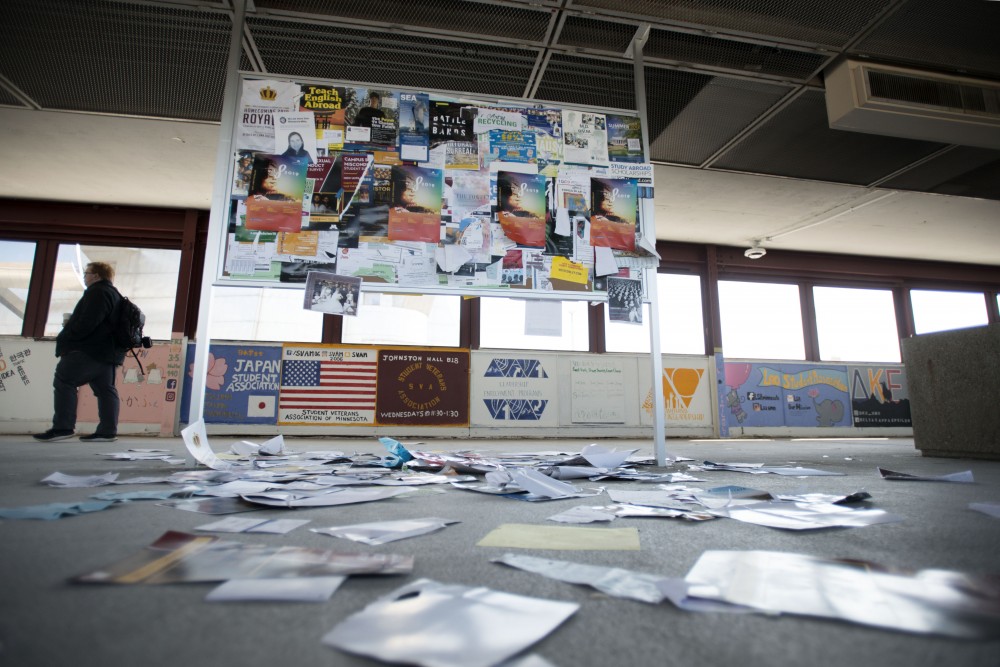 A pile of papers lay beneath a bulletin board on the Washington Avenue bridge on Tuesday, March 26.