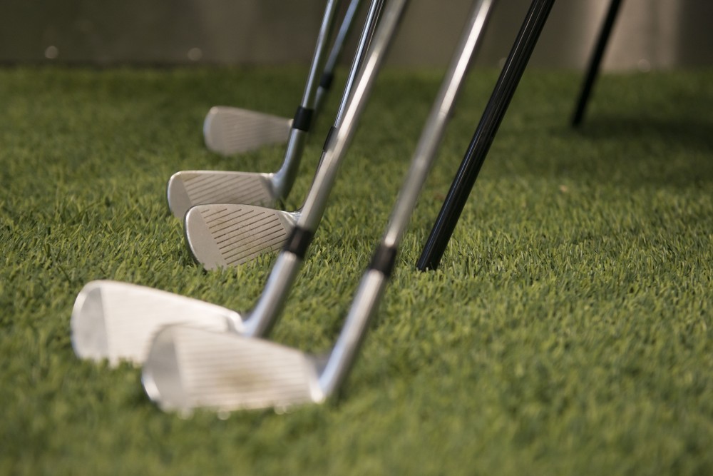 Clubs are lined up along the edge of the putting green at the new indoor golf training facility on Monday, April 1 in St. Paul. The facility borders the Les Bolstad Golf Course and allows for practice throughout winter months. 