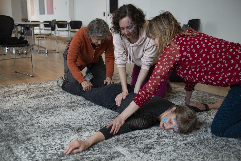Josie Winship, Theresa Madaus and Ashleigh Lambert massage Anna Marie Shogren in an experience about slowing down to show care at Slow Art Day at Weisman Art Museum on Saturday, April 6 in Minneapolis. Instead of spending fifteen seconds looking at pieces of art, Slow Art Day asks viewers to take fifteen minutes.