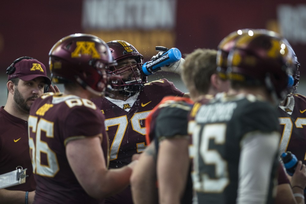Malcolm Robinson drinks water on Saturday, April 13 at the indoor football practice facility in Athletes Village.