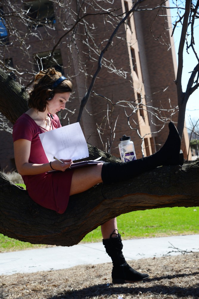 10:22 a.m.
Adrienne Birkeland sits on a tree branch outside of McNeal Hall on the St. Paul campus. 