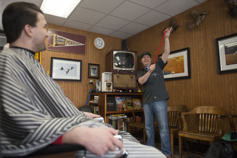 2:57 p.m.
Dan Griffin performs a magic trick for customers at Craigs Como Barbershop. 