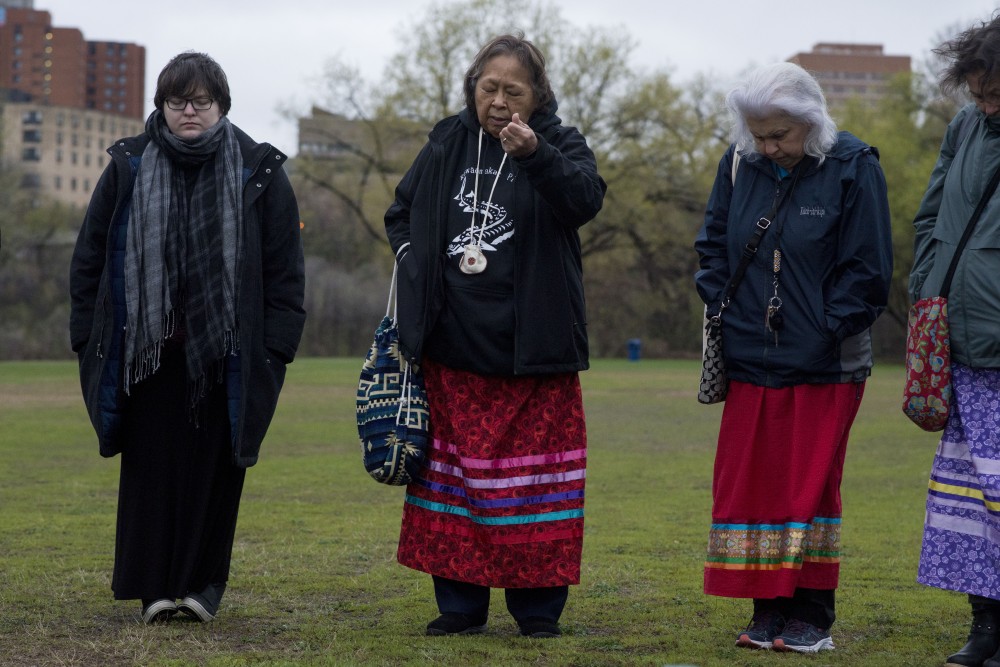 Nelda Goodman holds out a handful of tobacco during a prayer as part of a sunrise ceremony on East bank on Wednesday, May 1 to commemorate the beginning of American Indian Month. The ceremony concluded with a special tribute to missing and murdered indigenous women.