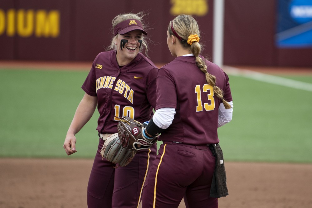 Juniors Katelyn Kemmetmueller and Amber Fiser celebrate after an out on Saturday, May 18 at the Jane Sage Cowles Stadium in Minneapolis. The Gophers beat the University of Georgia 2-1.