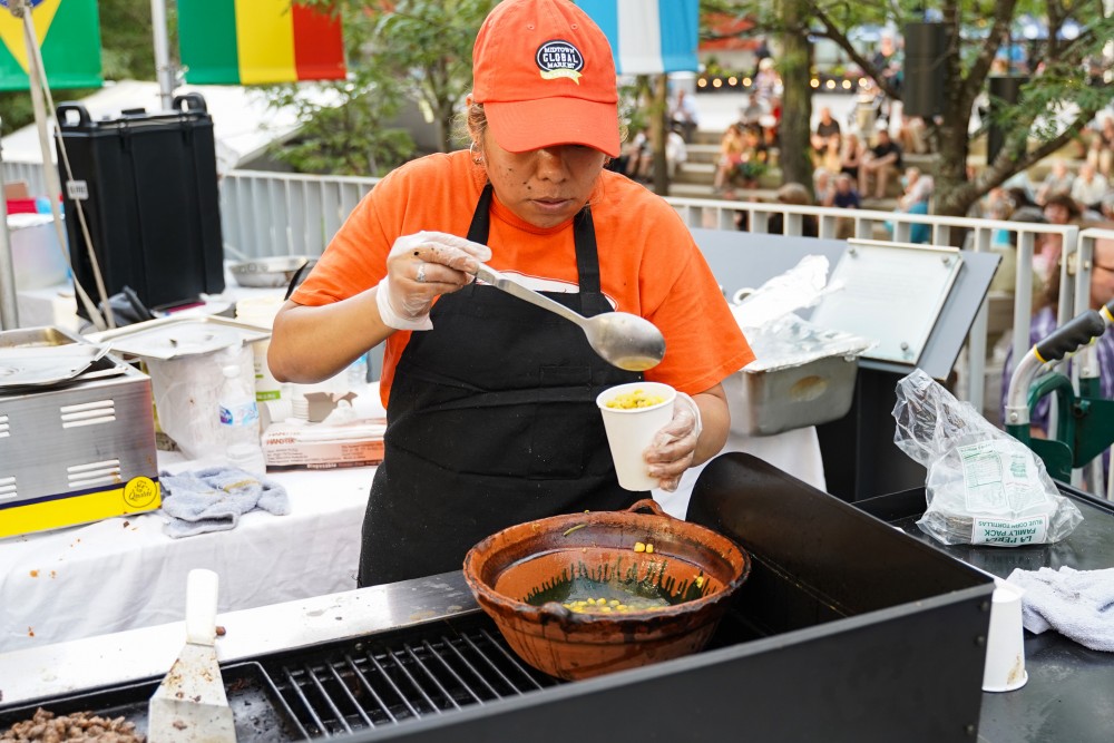 Lousia Fernán cooks authentic cuisine at a food cart for Musica Juntos at Peavey Plaza in Minneapolis on Friday, July 26.