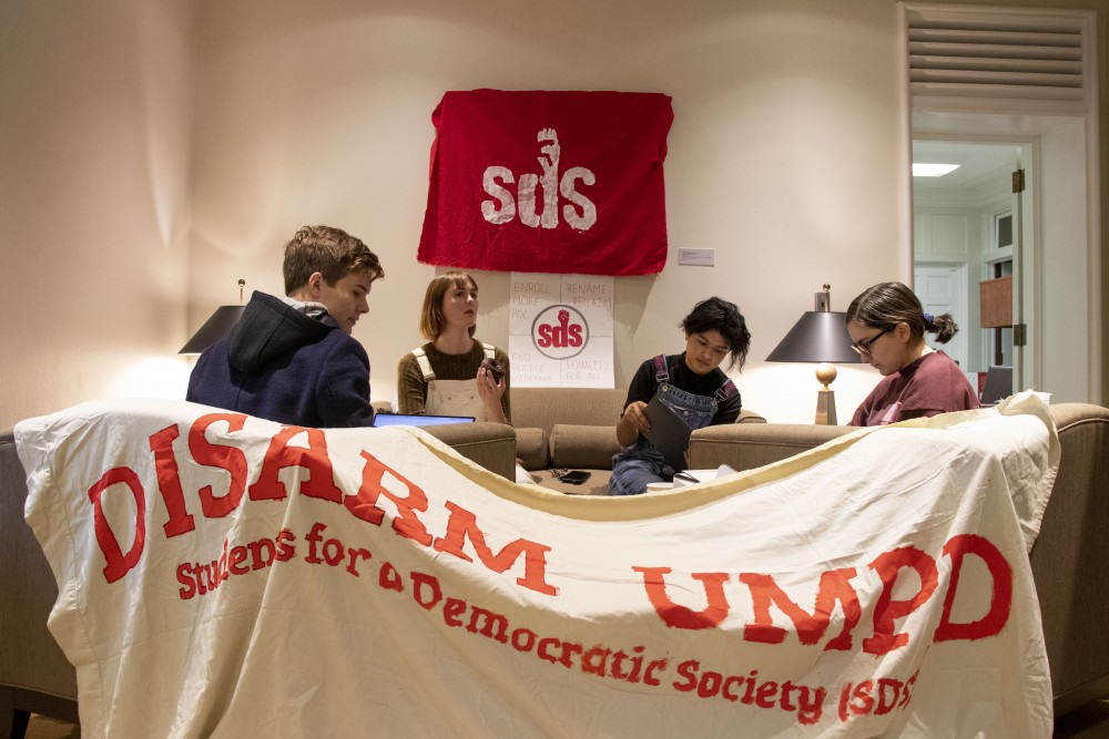 From left, Eric Dorland, Olivia Crull, Étienne Magdalen and Sondos Ibrahin congregate for a sit-in protest outside President Joan Gabels office on Friday, Oct. 4, 2019. The group, representing Students for a Democratic Society, studied and shared donuts and coffee in the office lobby. (Liam Armstrong / Minnesota Daily)
