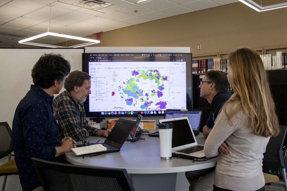 From left, Kyungsoo Yoo, Len Kne, Darrell Gerber and Melinda Kernile explore the mapping of data regarding drinking water supply with ArcGIS in the Collaborative Research Studio in Wilson Library on Friday, Oct. 11. 