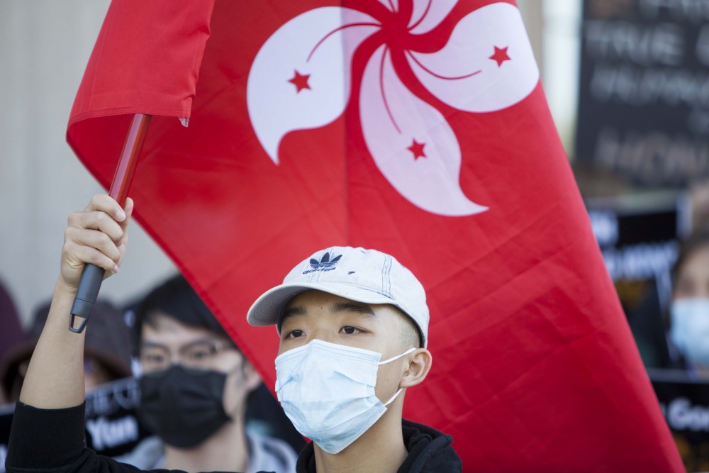 A pro-Hong Kong demonstrator hoists the Hong Kong flag outside Coffman Union on Friday, Oct. 18. Marchers traversed campus in an effort to raise awareness of the plight of the people of Hong Kong. 