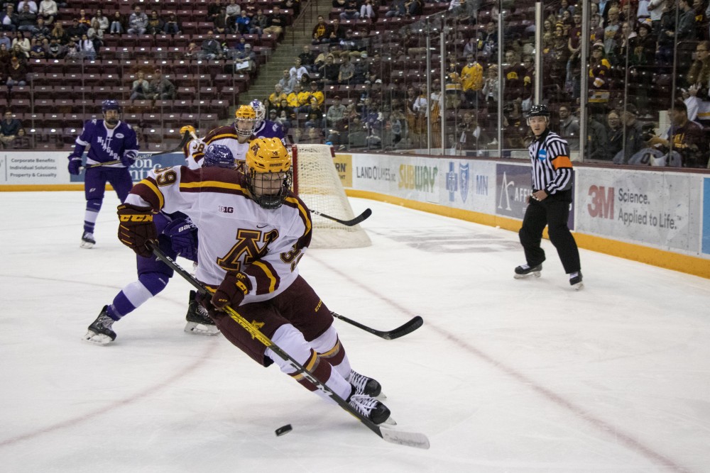 Forward Ben Meyers fights for the puck at 3M Arena at Mariucci on Friday, Oct. 18, 2019. The Gophers defeated Niagara 3-2.  