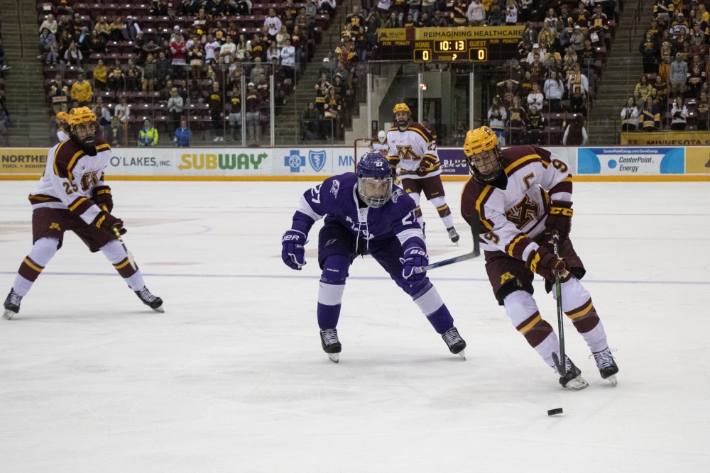 Forward Sammy Walker fights for the puck at 3M Arena at Mariucci on Friday, Oct. 18. The Gophers defeated Niagara 3-2. 