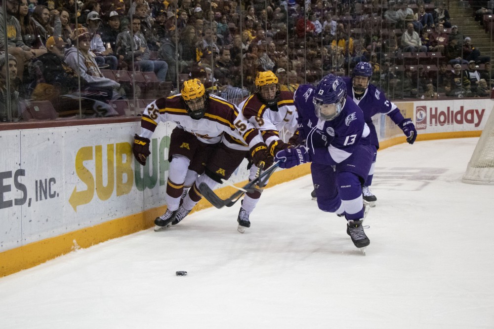 Forwards Jack Perbix and Sammy Walker fight for the puck at 3M Arena at Mariucci on Friday, Oct. 18. The Gophers defeated Niagara 3-2. 