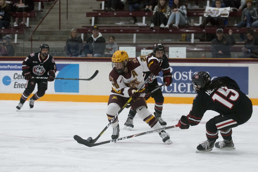 Forward Alex Woken fights for the puck at Ridder Arena on Saturday, Oct. 19. The Gophers defeated St. Cloud State 3-0.