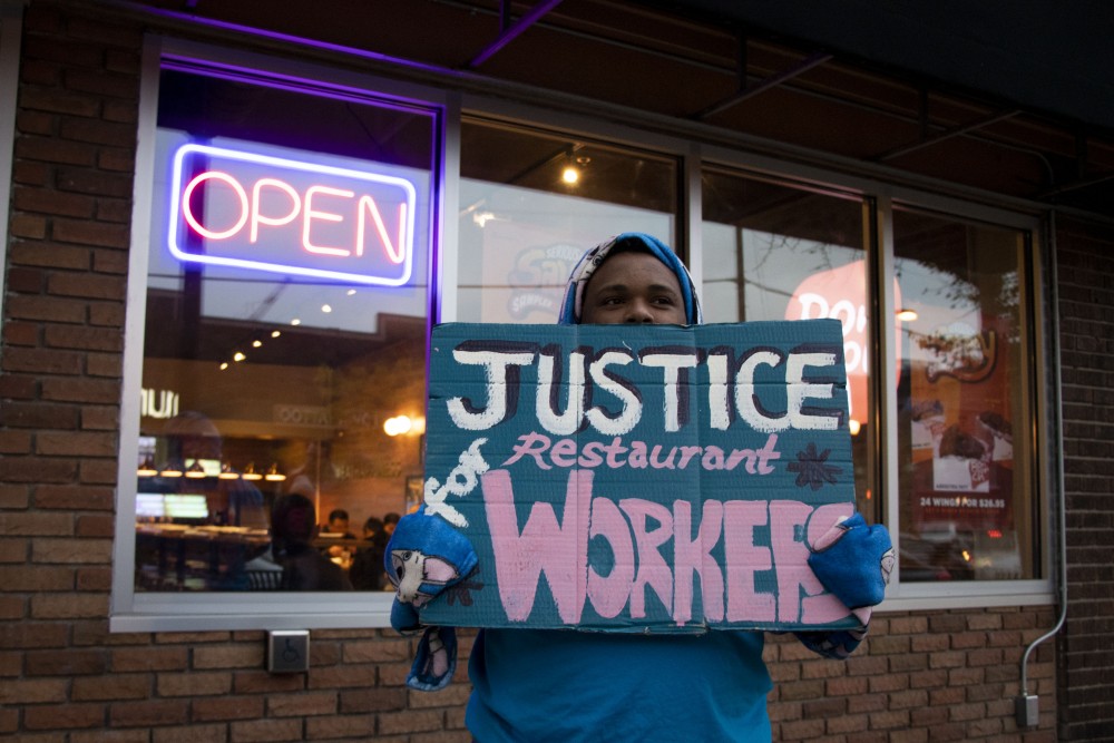 Members of the Restaurant Opportunites Center of Minnesota gather outside of Bonchon in Dinkytown to celebrate their victory in a recent settlement for stolen wages on Tuesday, Oct. 22. 