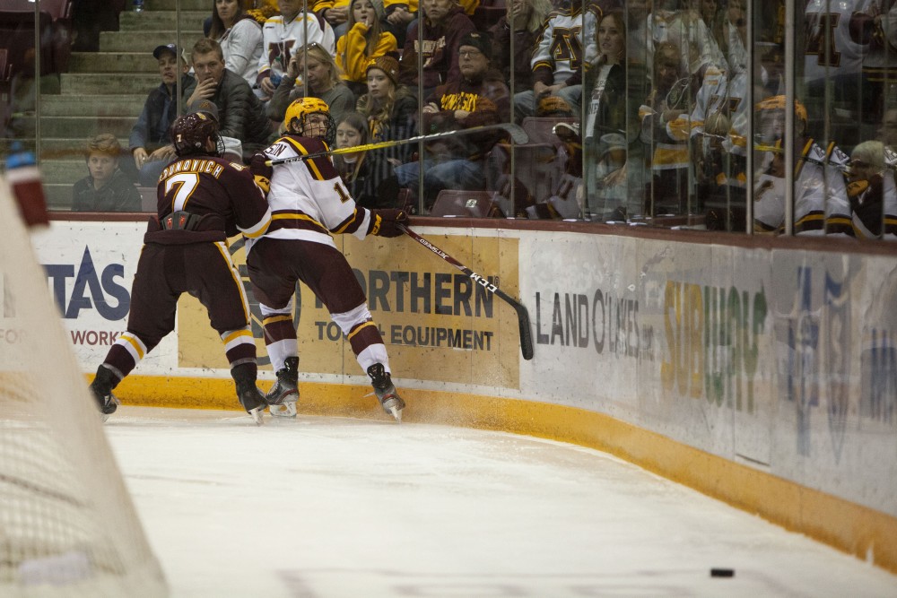 Forward Cullen Munson is forced into the glass at the 3M Arena at Mariucci on Friday, Oct. 25. The Gophers went on to lose 2-5 to the University of Minnesota Duluth. 