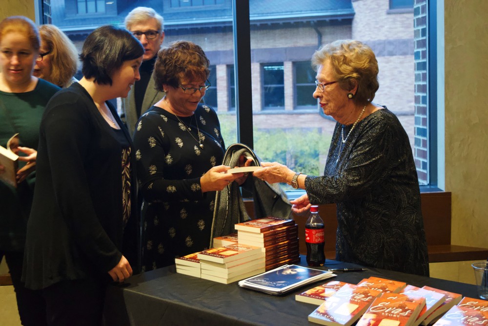 Holocaust survivor and step sister of Anne Frank, Eva Schloss, signs copies of her memoir during an event at Northrop Auditorium on Sunday, Oct. 27. (Emily Urfer / Minnesota Daily)