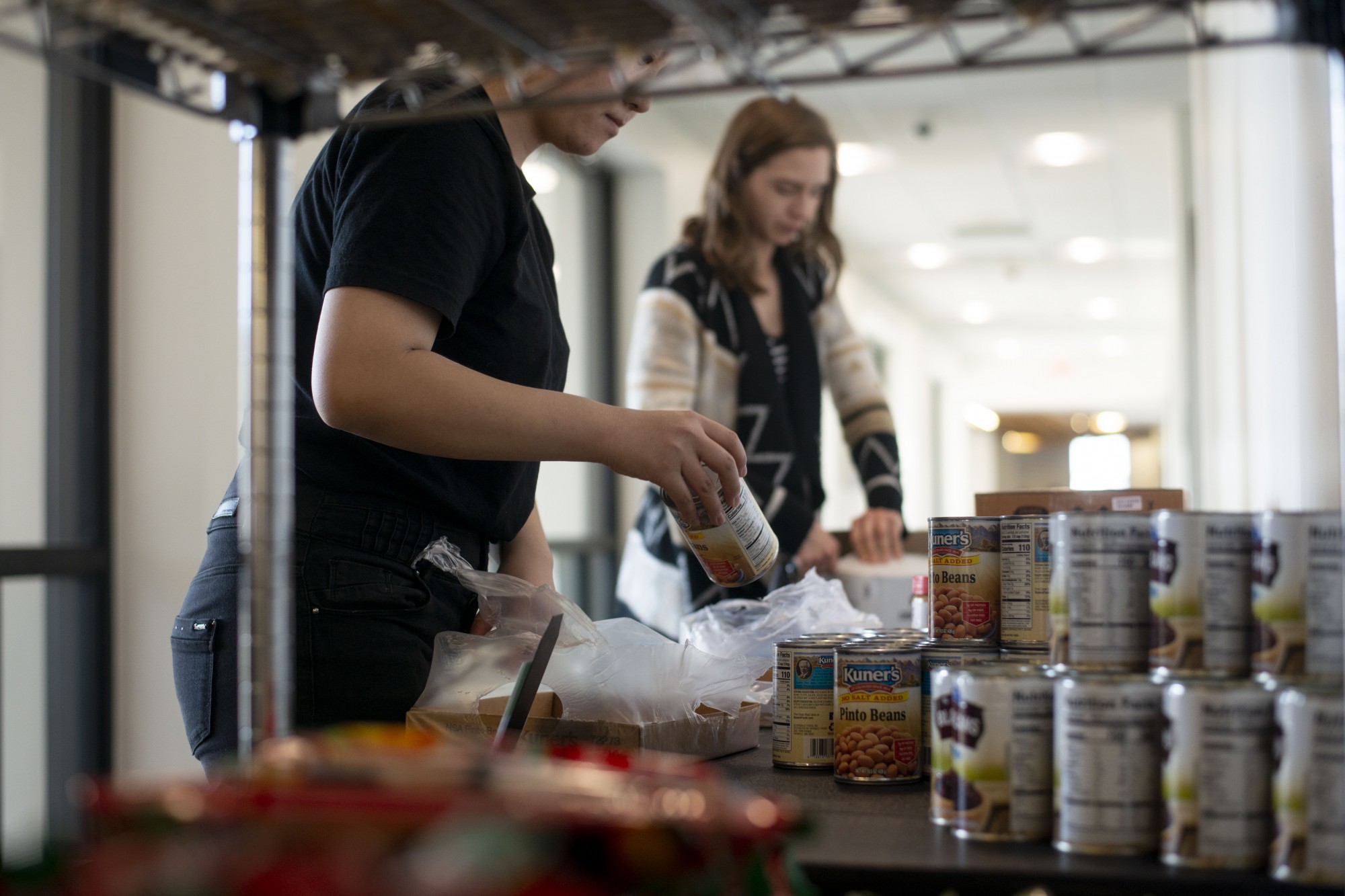 Volunteers Amber Chang, left, and Merri Bonde, right, prepare the Nutritious U Food Pantry to open in Coffman Union on Tuesday, Oct. 29. 