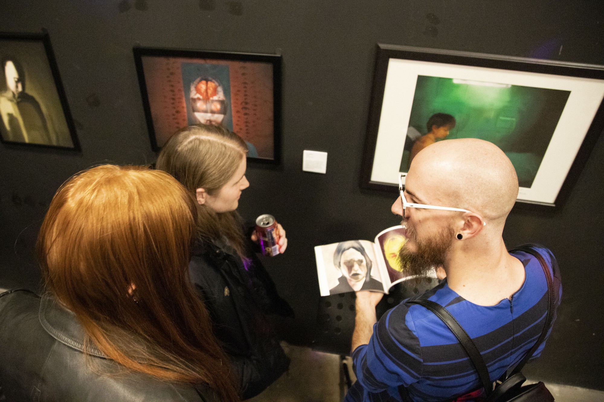 Chris Masanz, Ana Rockbell and Alec Lossiah admire art at Malleable, an exhibition by and for trans women and trans femme artists, in Minneapolis on Thursday, Nov. 7.