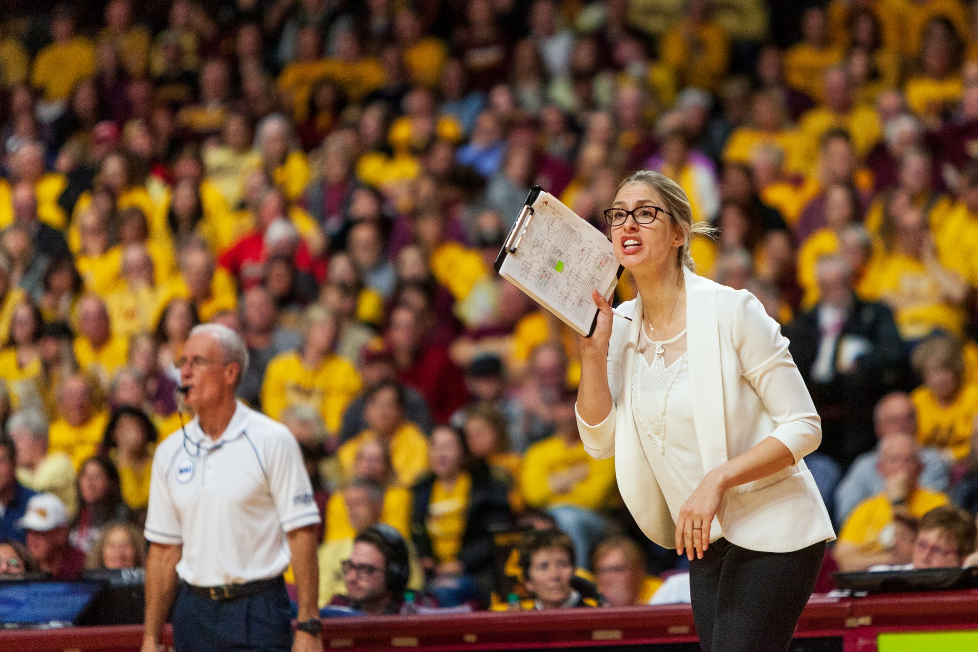 Associate Head Coach Laura Kasey yells from the sidelines at the Maturi Pavilion on Thursday, Nov. 14. The Gophers ended the night with a 3-1 loss against the Badgers. 