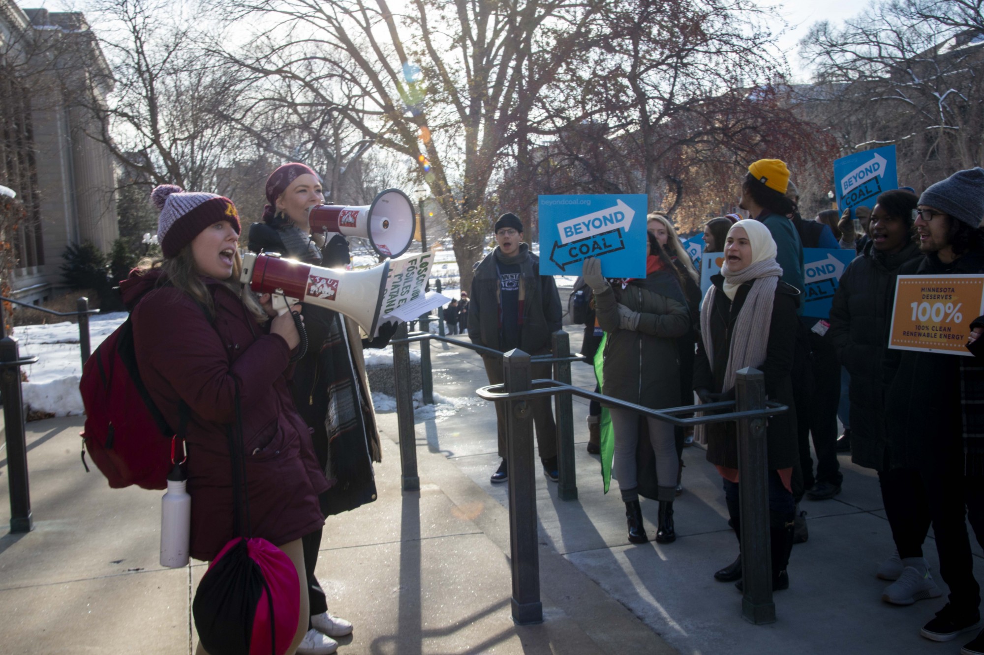 Savannah Wery, left, and Katherine Schmid, right, speak to protesters participating in the UMN Climate Strike outside of Morrill Hall on Friday, Dec. 6. Those in attendance criticized the University’s policies on fossil fuel usage.