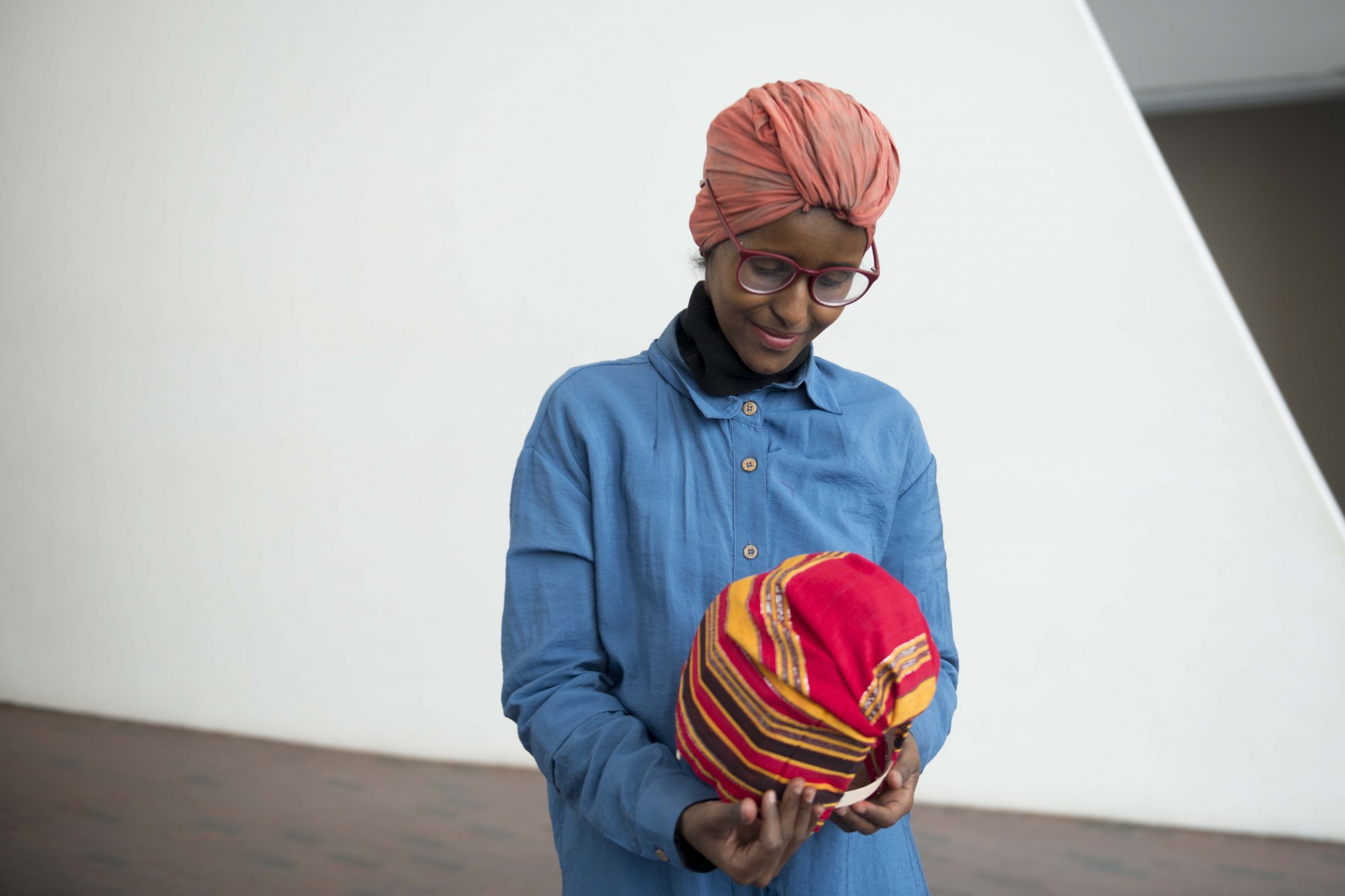 Artist and teacher Ifrah Mansour looks at a miniature Aqal, a traditional nomadic Somali hut, she created an exhibit she  hosted at the Walker Art Center on Saturday, Dec 7. A Somali refugee herself, Mansour aims to create art that promotes social justice. 