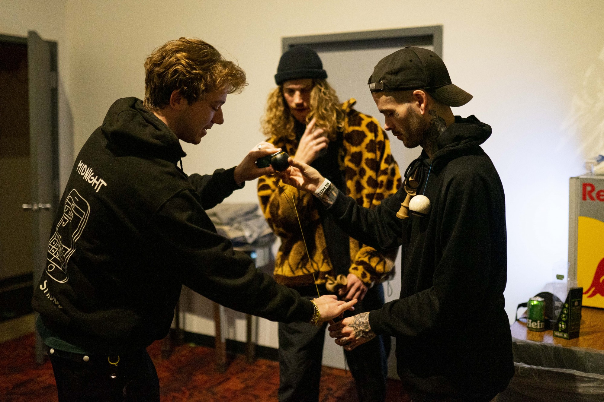Eddy, left, assists Pat Lundy, right, with the move, “one turn lighthouse,” backstage before Lundy goes on to perform with his band, Modestep, on Wednesday, Nov. 27. Eddy and Reed, center, met Lundy in London in April where they stayed up until 4 a.m. learning new tricks together. 