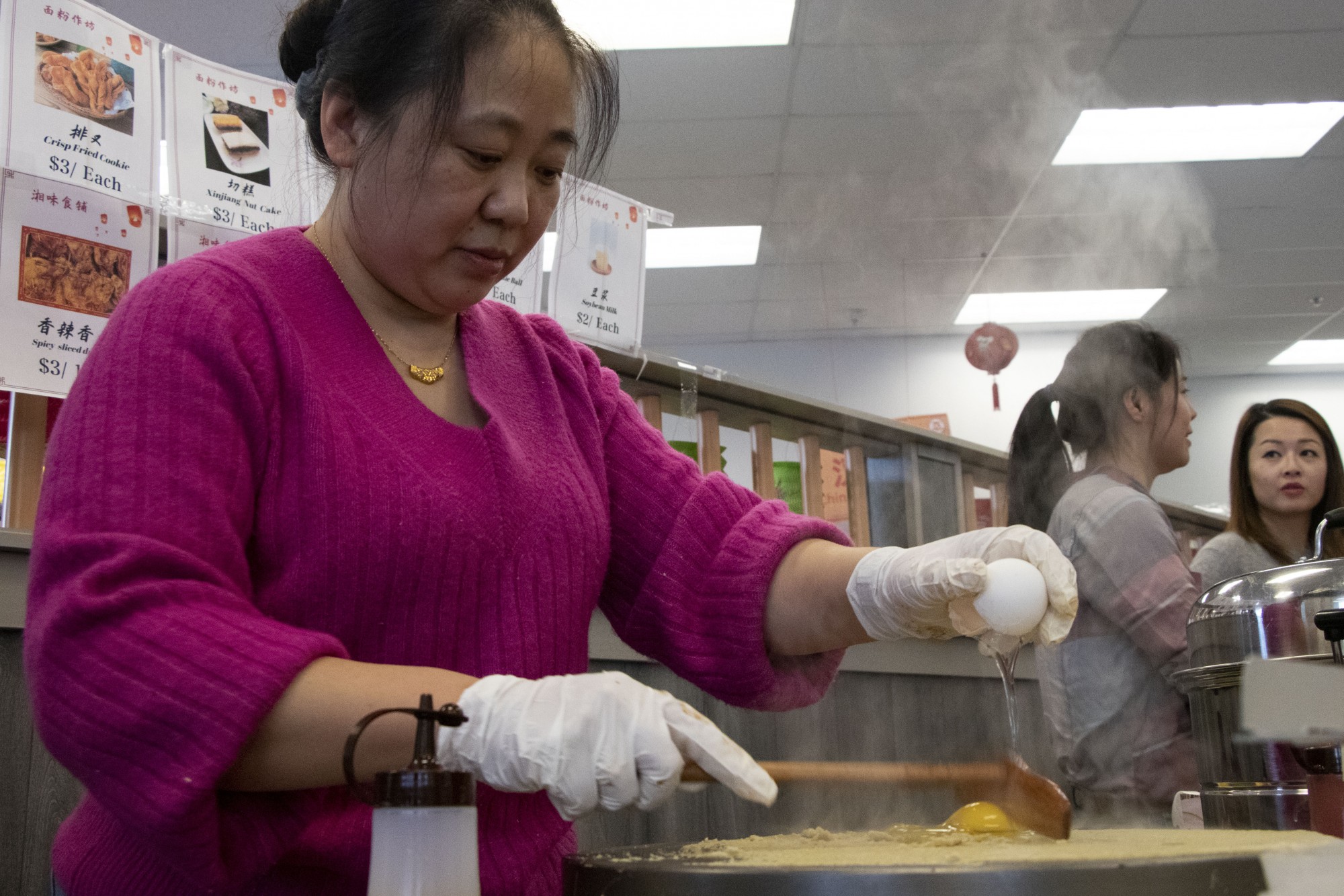 Qingjun Zhang prepares Tianjin crepes at the Lunar New Year celebration at University Food Hall in Dinkytown on Sunday, Jan 26. The crepes are a traditional northern Chinese food, one of many dishes available for purchase at the celebration. 