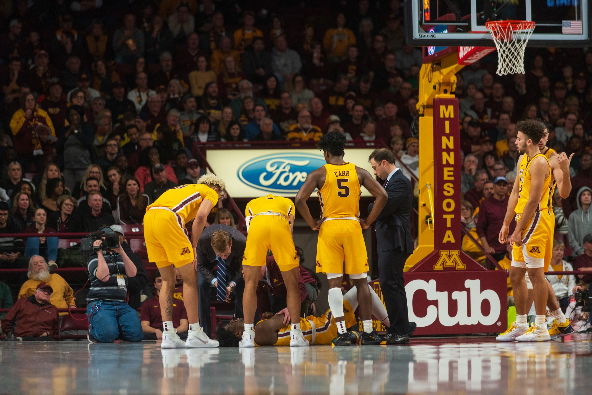 Gophers players surround Center Daniel Oturu as he lies on the floor after a foul at Williams Arena on Sunday, Jan. 12. Minnesota defeated Michigan 75-67. (Nur B. Adam / Minnesota Daily)