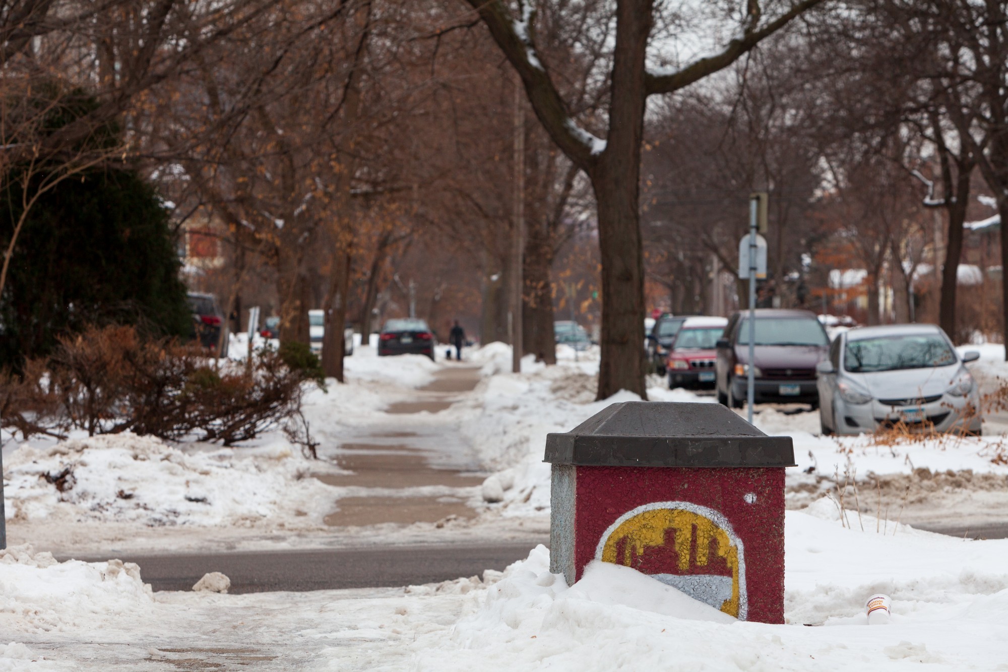 A trash bin adorned with the silhouette of Minneapolis is half buried in snow in the Marcy Holmes neighborhood on Tuesday, Jan. 28.  The neighborhood provides housing for a significant number of University students.