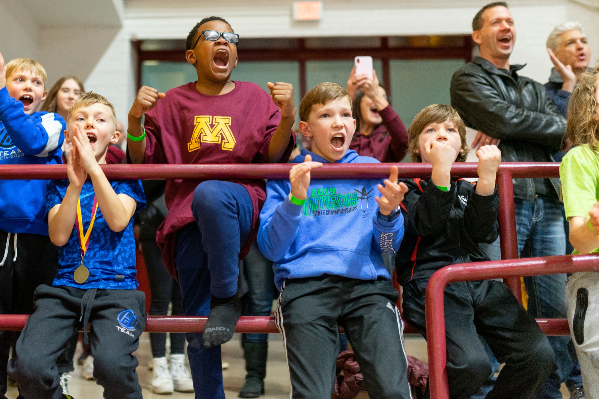 Young fans cheer as Gophers Junior Russell Johnson completes a routine on the high bar. The Gophers went on to a 398-375.55 victory over the Washington Huskies.
