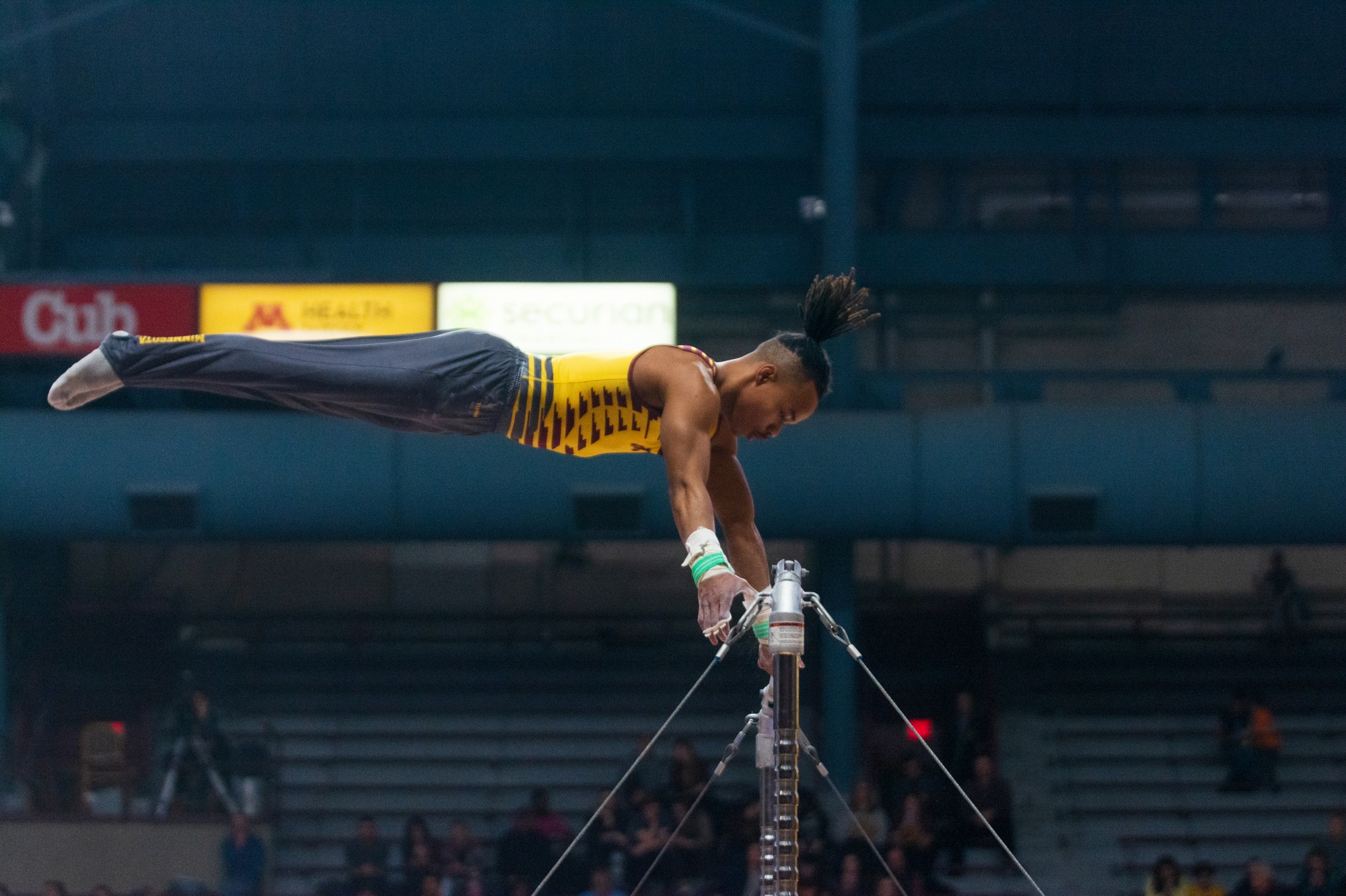 Gophers Junior Russell Johnson performs a routine on the parallel bars at Maturi Pavilion on Friday, Feb. 7. The Gophers went on to a 398-375.55 victory over the Washington Huskies.
