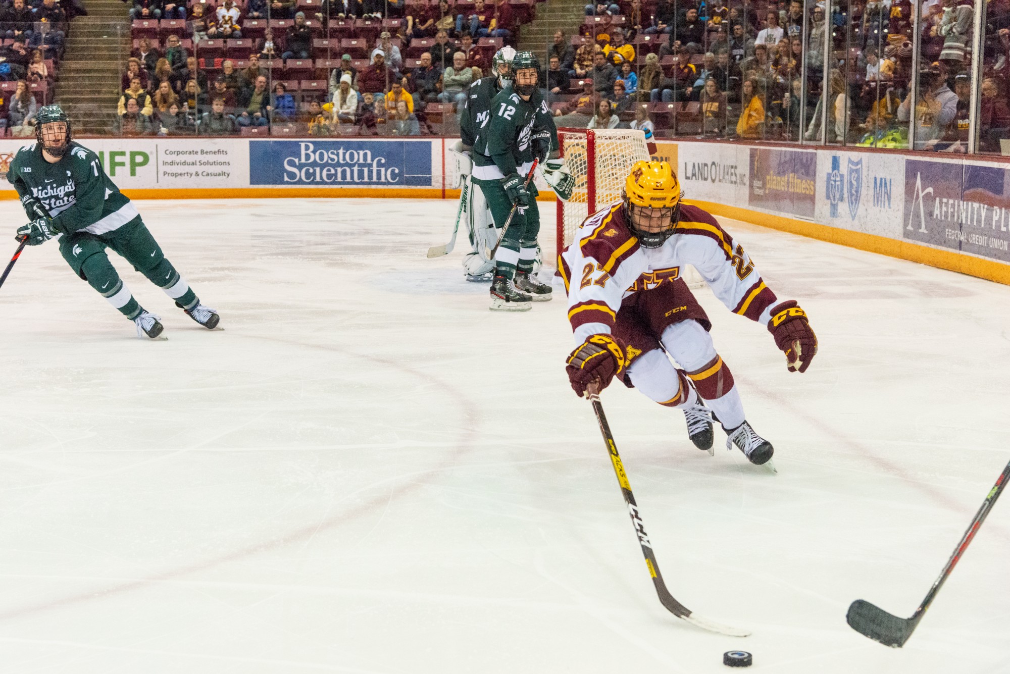 Gophers Forward Blake McLaughlin rushes to take the puck from a defender at the 3M Arena at Marriucci on Friday, Feb. 7. Gophers won against Michigan State 4-1.