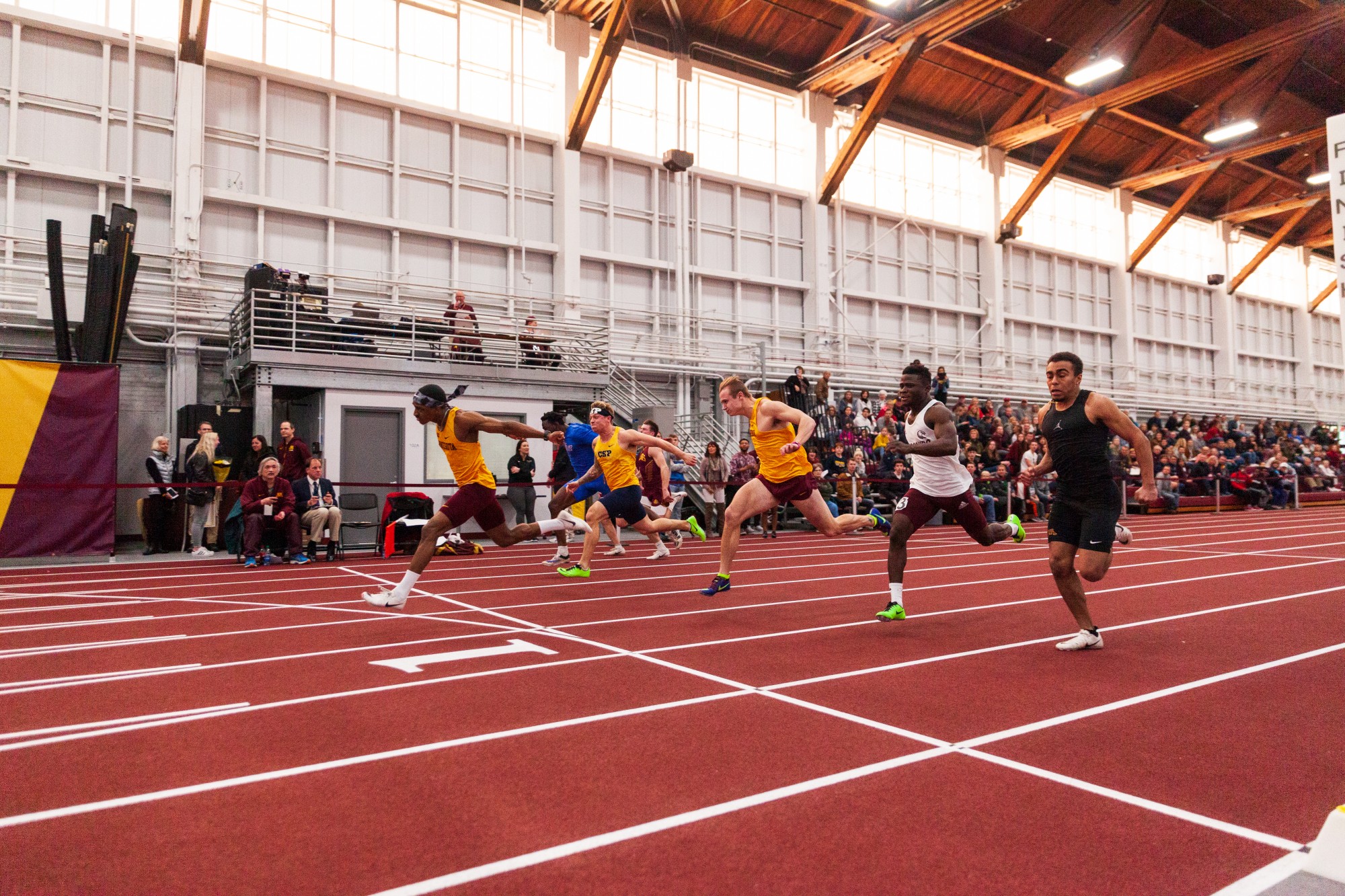 Gophers Freshman Kion Benjamin lunges for the finish line of the sixty meter dash at the Minnesota Cold Classic at the University of Minnesota Fieldhouse on Friday, Feb. 21.