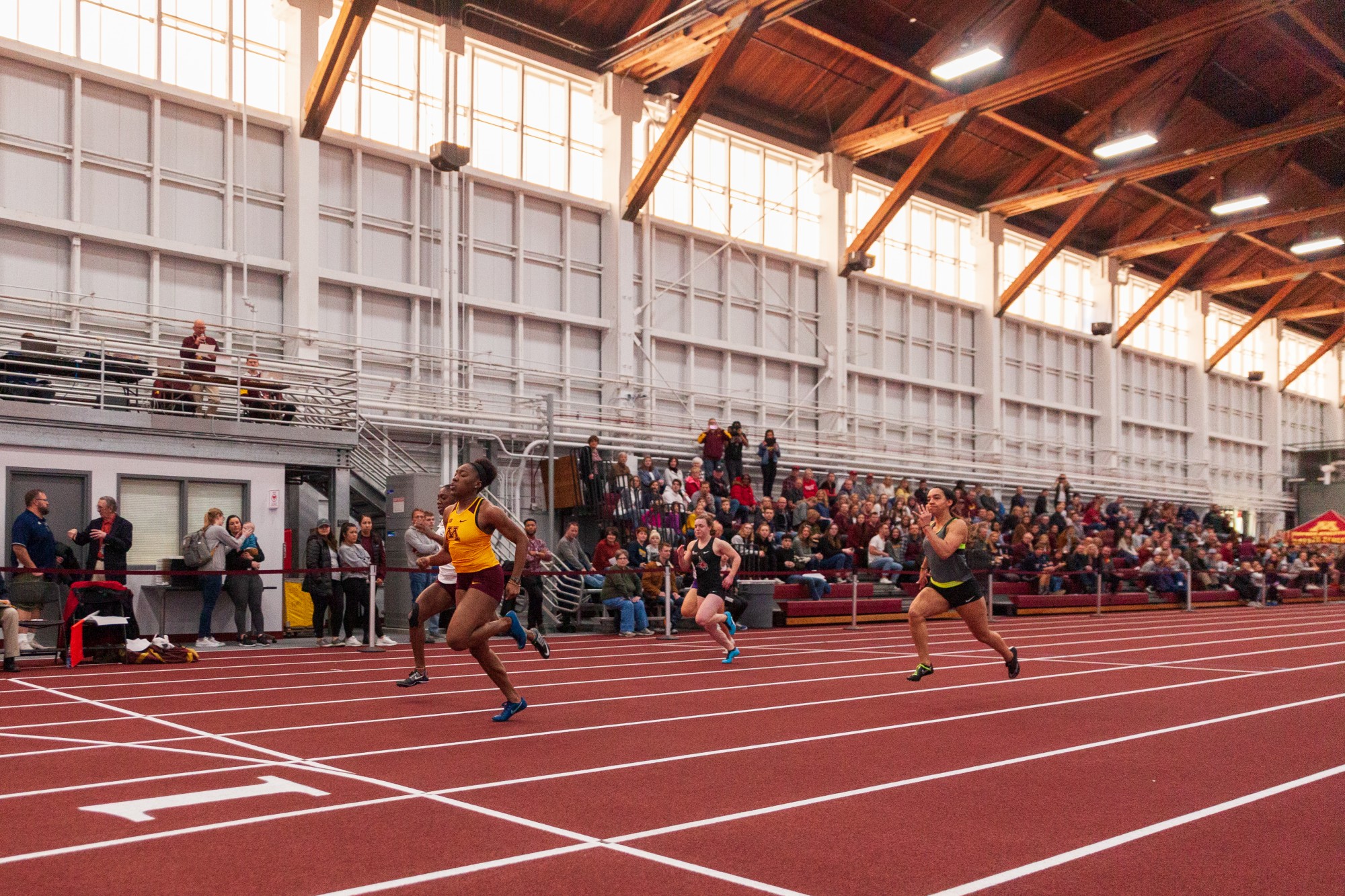 Gophers Freshman Akilah Lewis lunges for the finish line of the sixty meter dash at the Minnesota Cold Classic at the University of Minnesota Fieldhouse on Friday, Feb. 21.