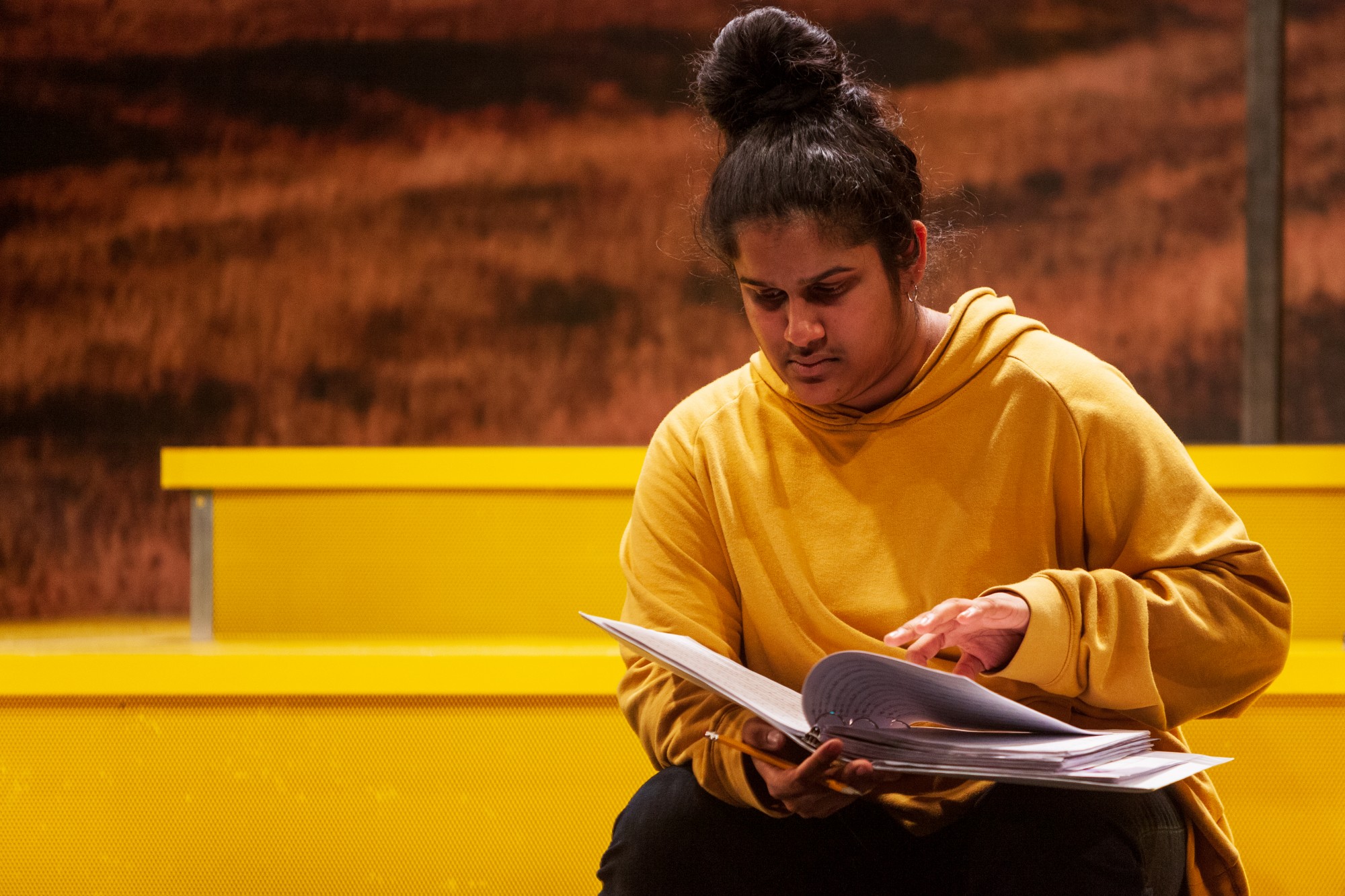 Actress Sushma Saha flips through her notes during a rehearsal of Interstate at MixedBlood Theatre on Tuesday, Feb. 18. The production, created by Kit Yan and Melissa Li, follows the experiences of two trans people, navigating a myriad of cultural issues.