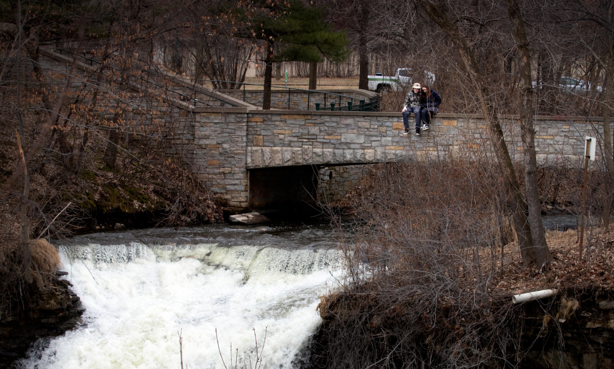 Brode Benish, a first year student at the University of St. Thomas and Sophia Rossman, a first year student at St. Catherine University, sit on Bridge 1 over Minnehaha Falls in Minnehaha Regional Park in Minneapolis on Wednesday, March 25. 