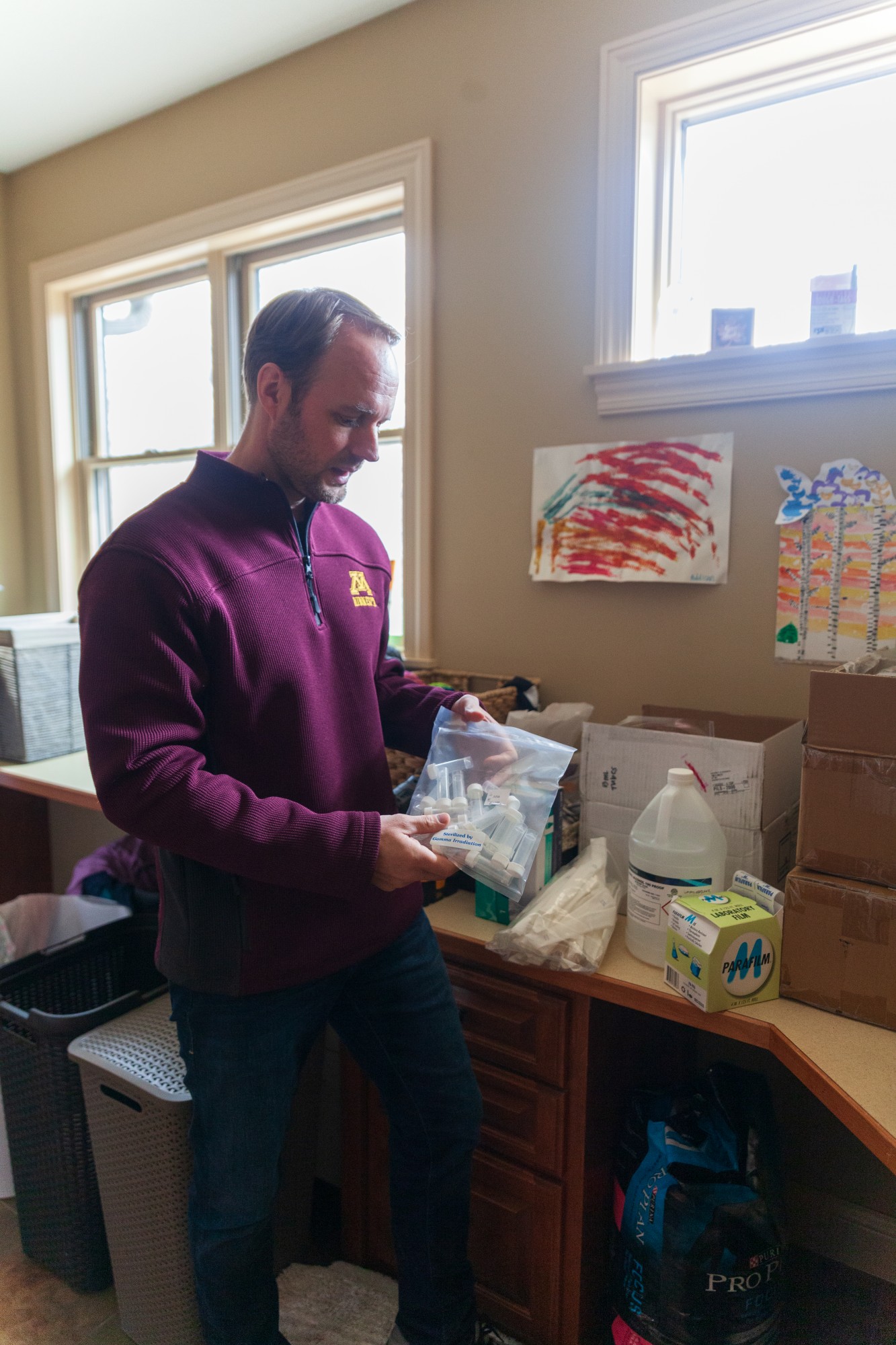 Associate Professor of Epidemiology Ryan Demmer, PhD., discusses the components of a testing kit for COVID-19 in his home on Friday, April 10.  The kit is being used to collect research data on the rate of asymptomatic infections among healthcare workers in the Twin Cities metro area.