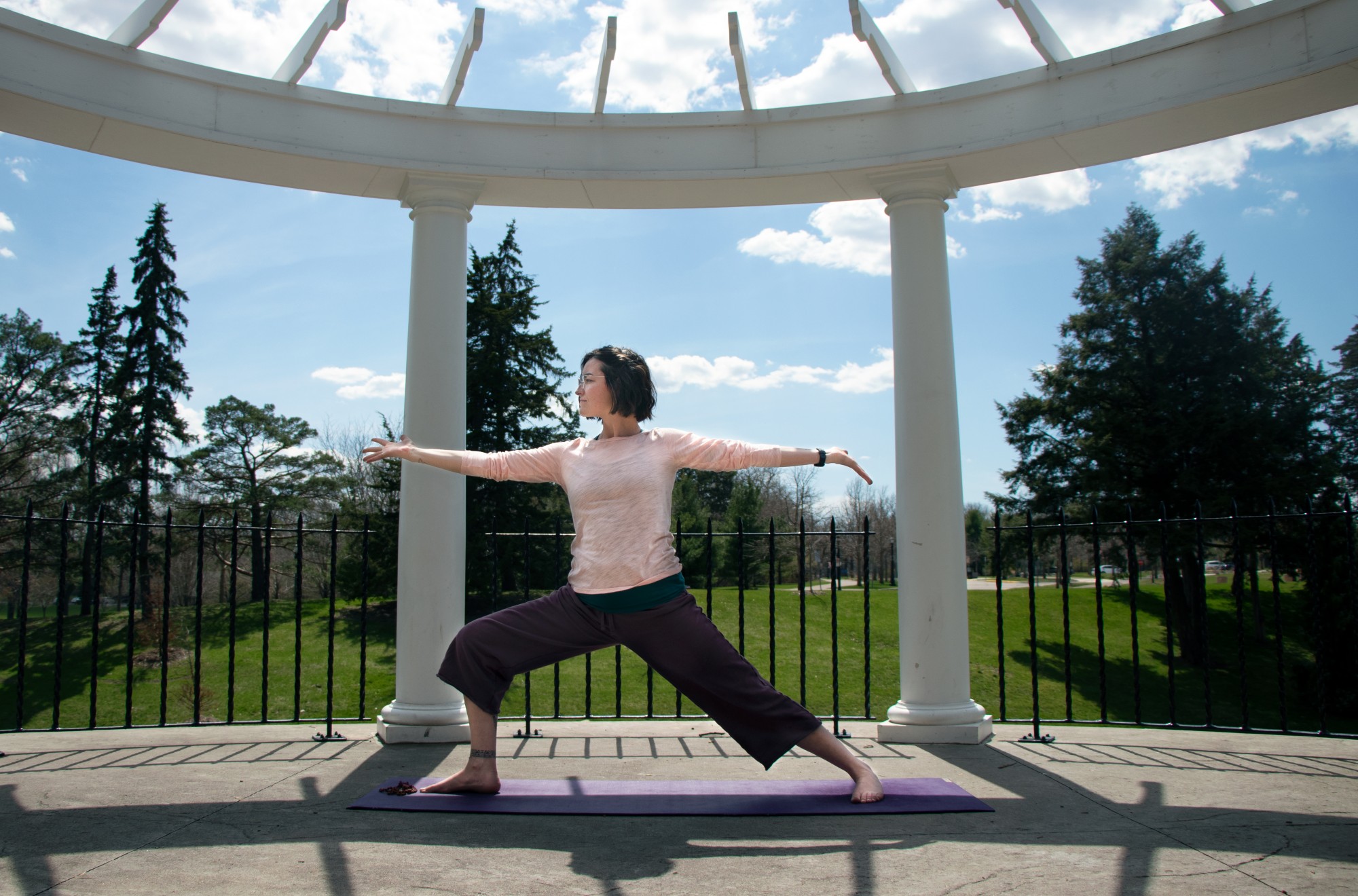 Tessa Rose performs the Warrior II pose in Como Regional Park on Monday, April 27. Rose instructs both traditional yoga and meditation based classes online. In her teaching, Rose believes that the mental aspects of yoga are often more important than the physical. 