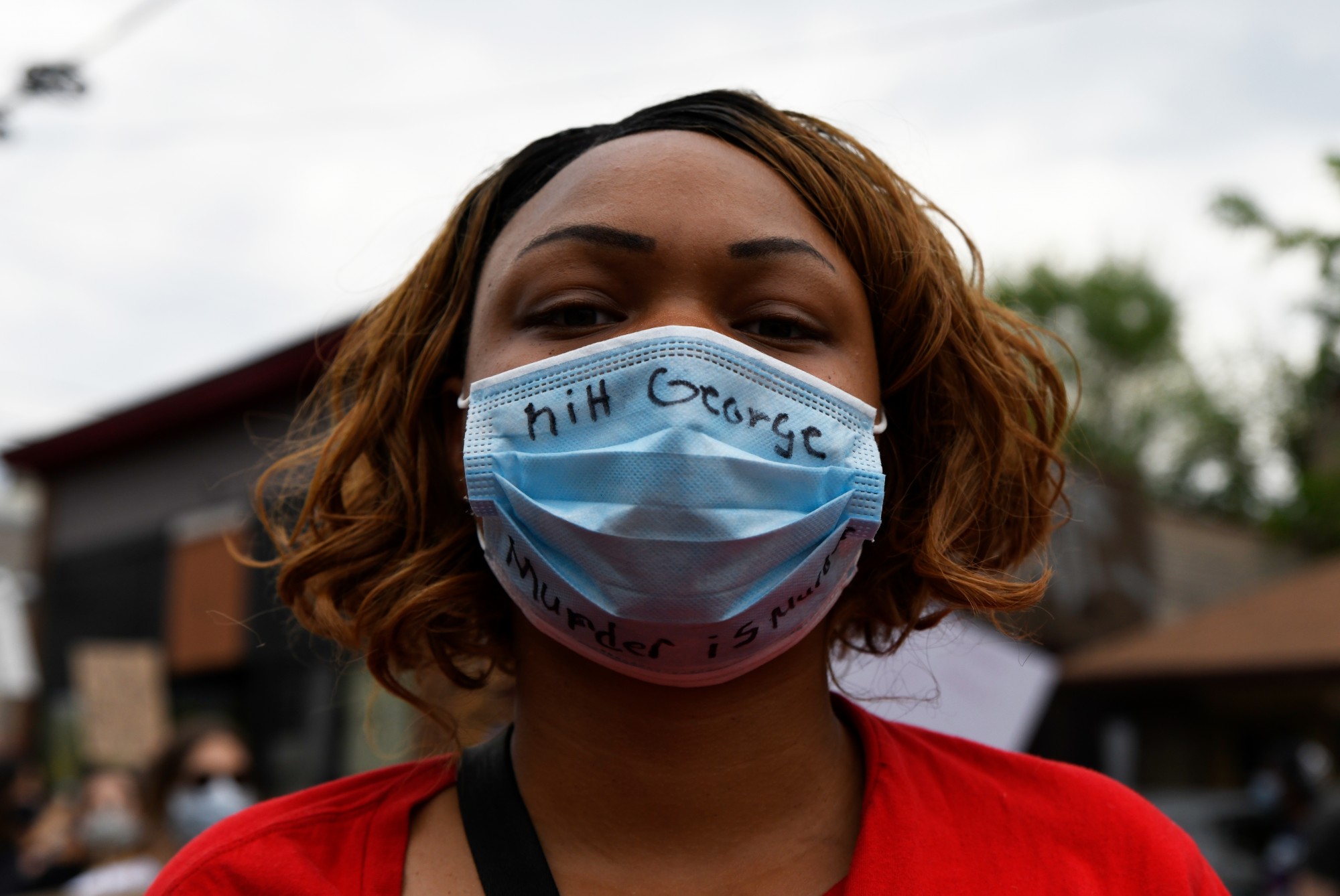 Alyssa Plunkett poses for a portrait wearing a mask that reads “RiH George” and “Murder is Murder” during the protest near Cup Foods on Chicago Avenue South in Minneapolis on Tuesday, May 26. Plunkett lives in the neighborhood and goes by Cup Foods every day. “This is my community, I’m not going to walk in fear,” Plunkett said. The protest was in response to the death of George Floyd in police custody. 
