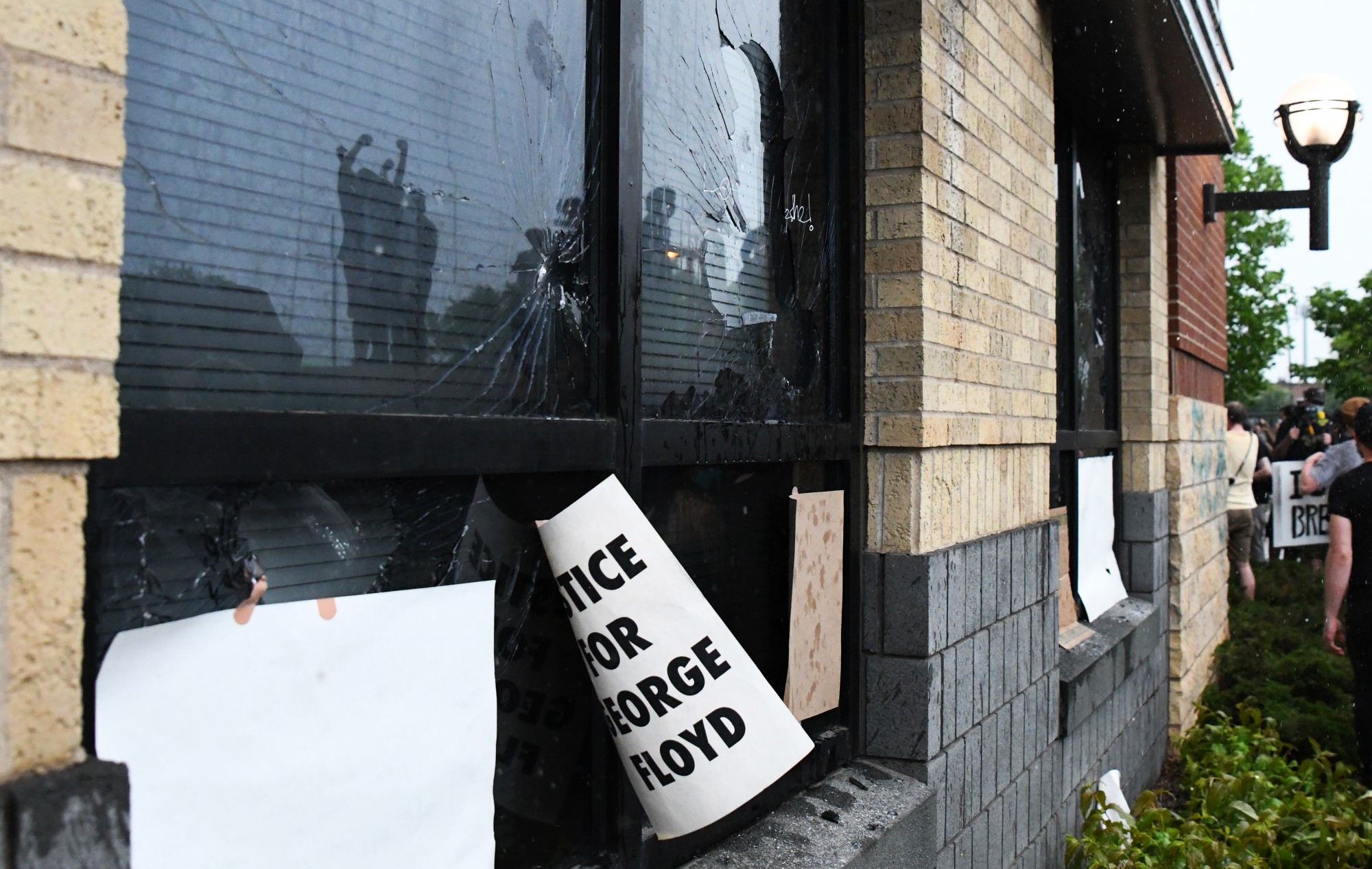 A sign reading “Justice for George Floyd” is taped to a window that was broken by protesters at the Minneapolis 3rd Police Precinct on Minnehaha Ave on Tuesday, May 26. The protest was in response to the death of George Floyd in police custody. (Andy Kosier / Minnesota Daily)