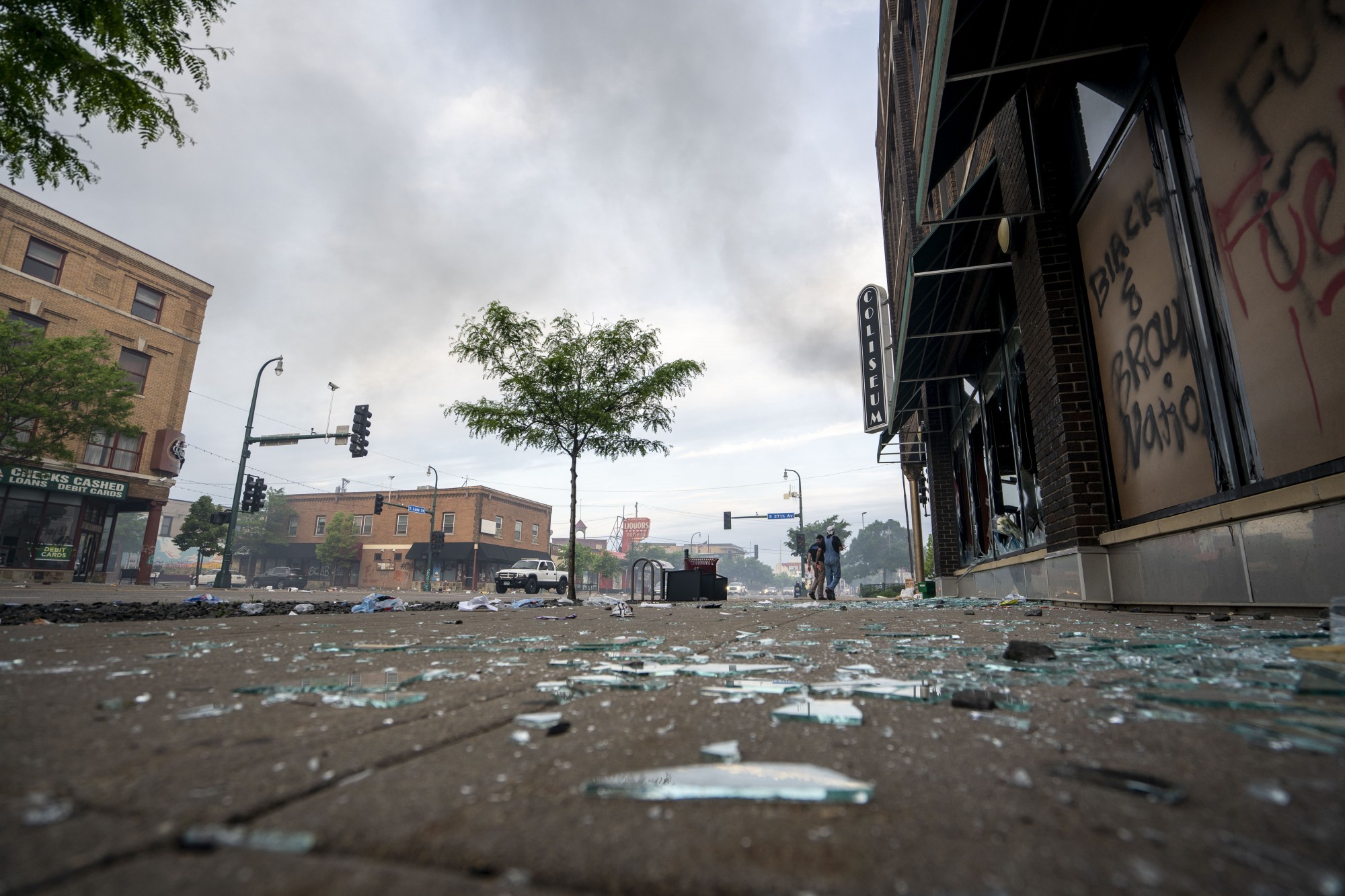 Broken glass litters the sidewalk on Lake Street the morning after a second night of protests that turned violent near the Minneapolis Police 3rd Precinct following the death of George Floyd. Dozens of businesses were vandalized and firefighters were still working to control several blazes still at hand on Thursday, May 28.
