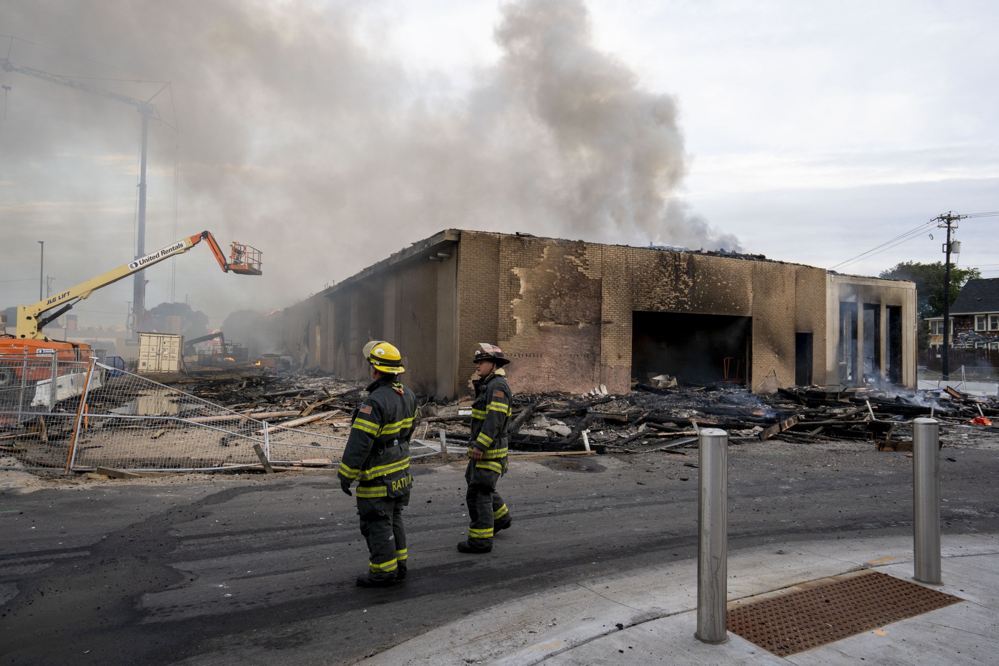 Minneapolis firefighters observe damage the morning after a second night of protests that turned violent near the Minneapolis Police 3rd Precinct on Thursday, May 28. 