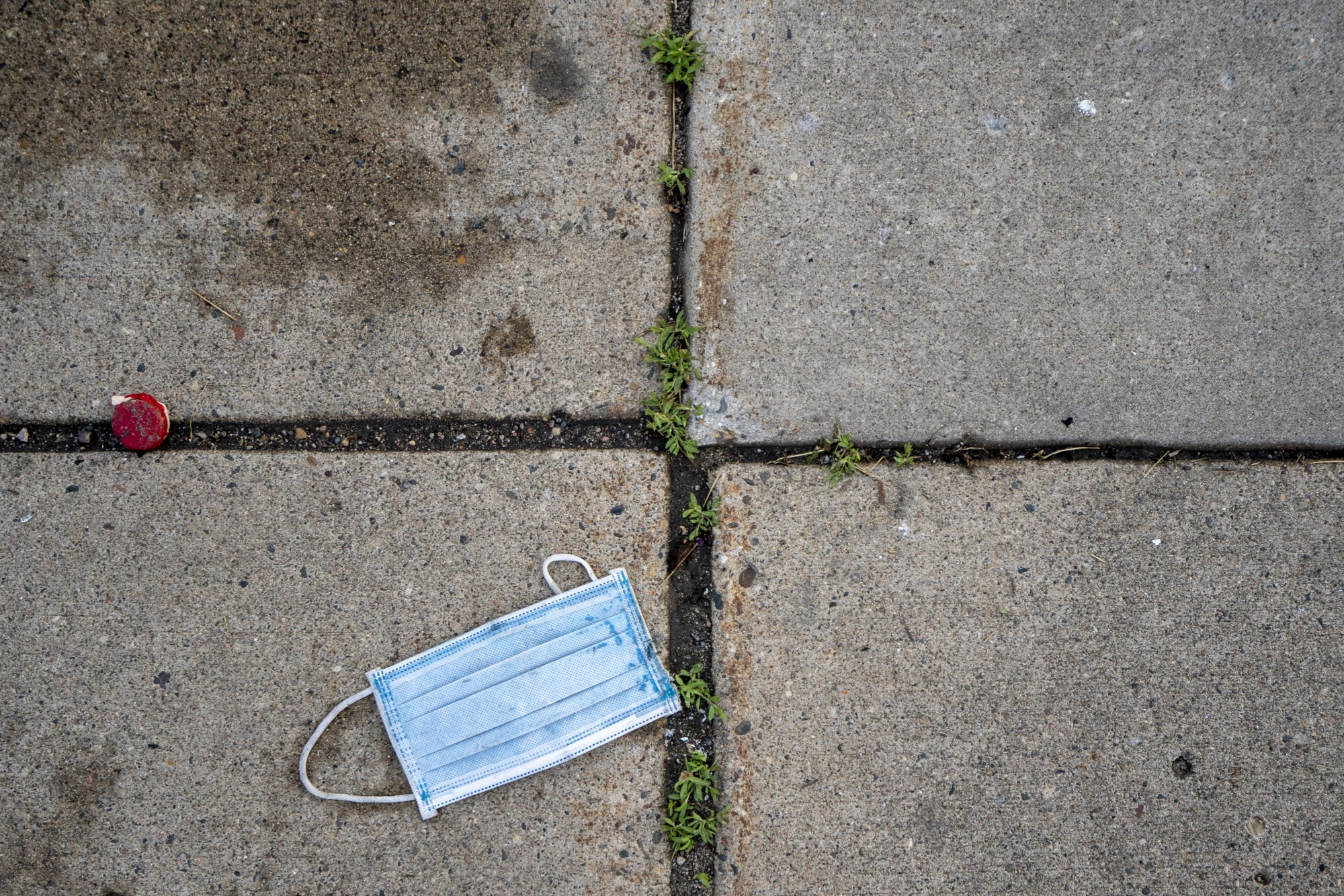 A face mask is seen on the ground the morning after a second night of protests that turned violent near the Minneapolis Police 3rd Precinct following the death of George Floyd. Dozens of businesses were vandalized and firefighters were still working to control several blazes still at hand on Thursday, May 28. 