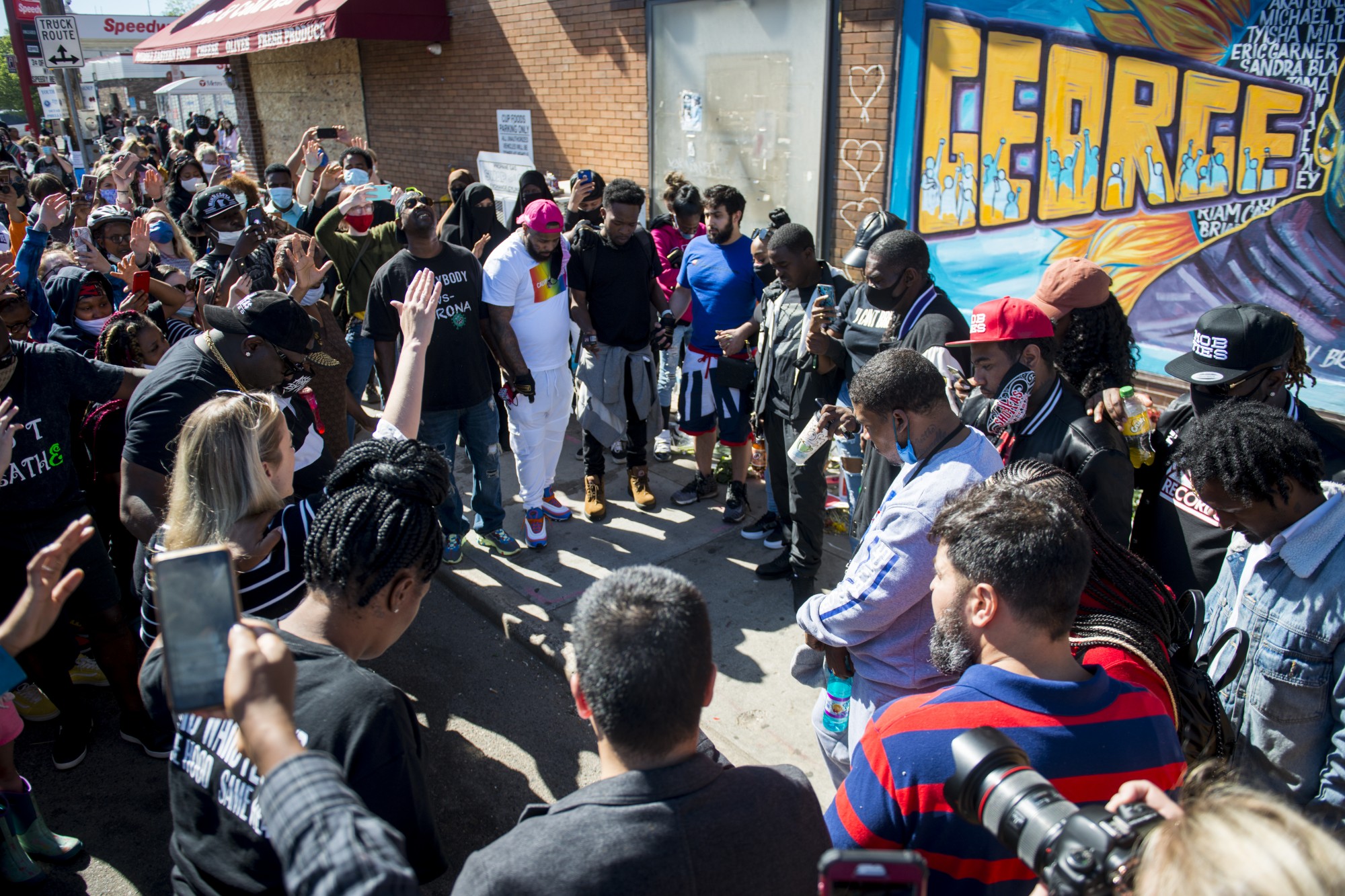 Pastor Anne Kadue leads a ministry of presence near the intersection of Chicago Avenue and East 38th Street at a memorial established to honor George Floyd on Friday, May 29. Members of Floyds family from Houston were in attendance and were the focus of the prayer. 