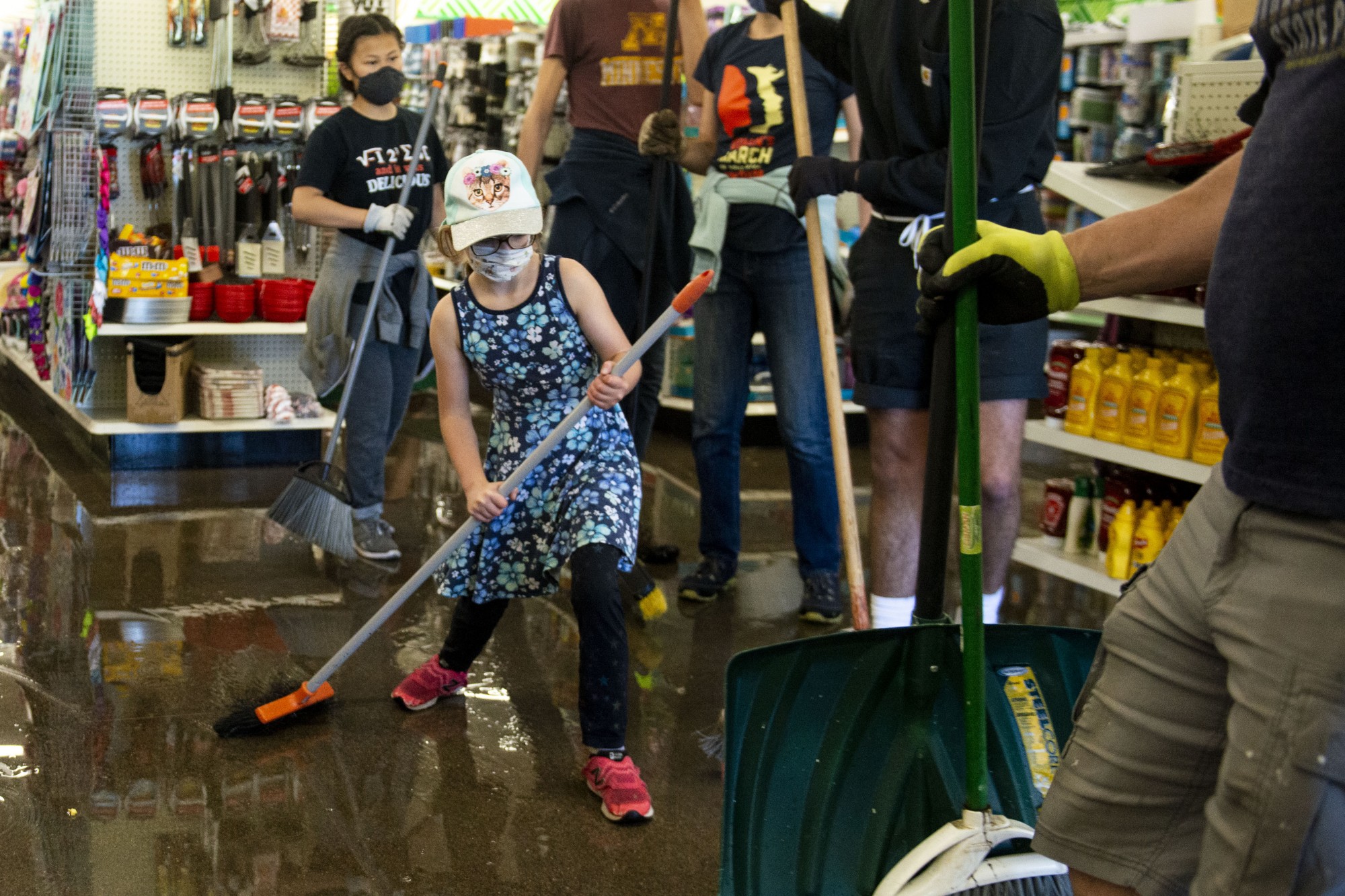 Abby Friedman, 9,  helps to sweep water out of Dollar Tree near the Minneapolis 5th Police Precinct following another night of riots on Saturday, May 30. 