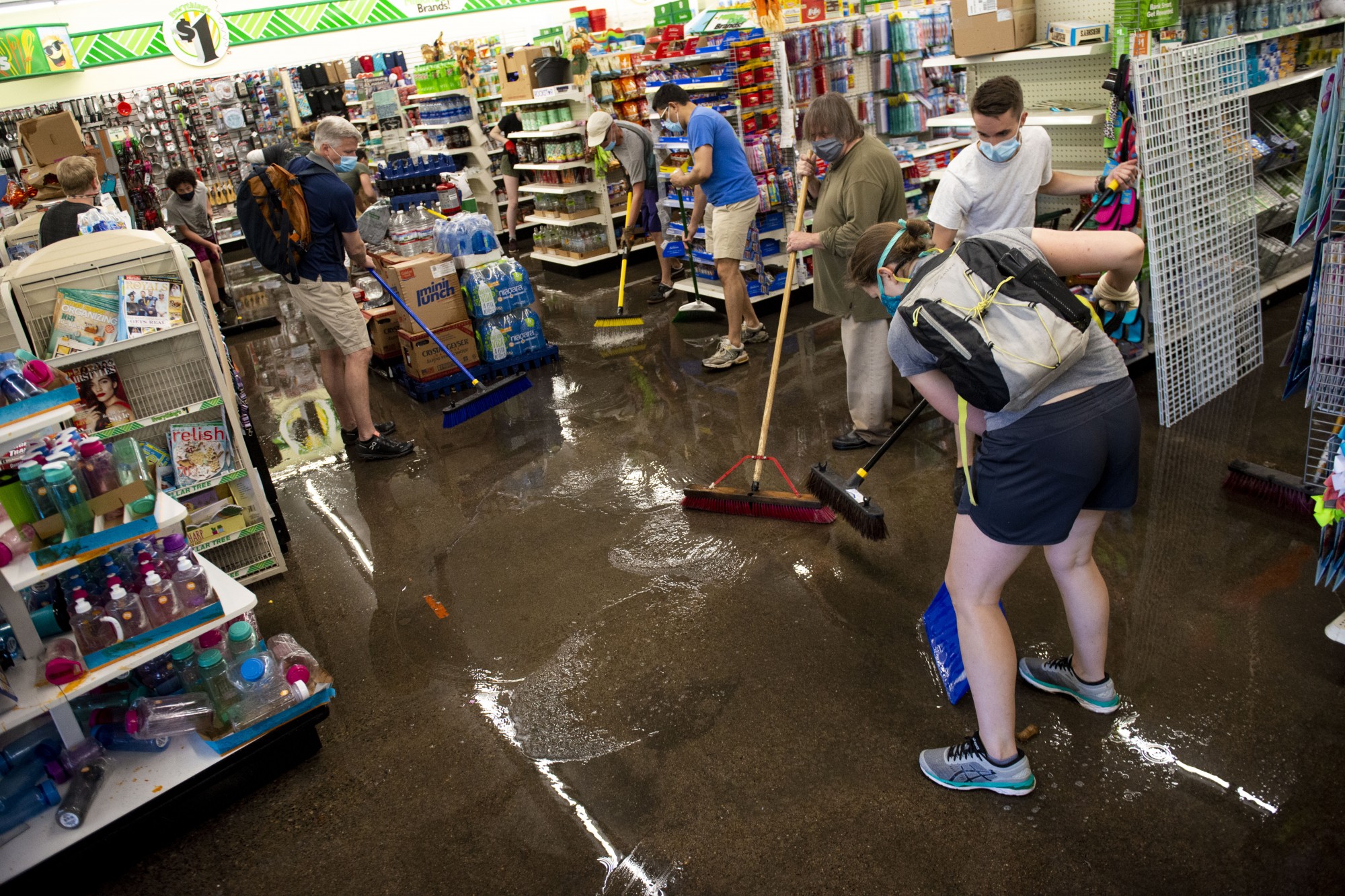 Volunteers help to sweep water out of Dollar Tree near the Minneapolis 5th precinct following another night of riots on Friday. 