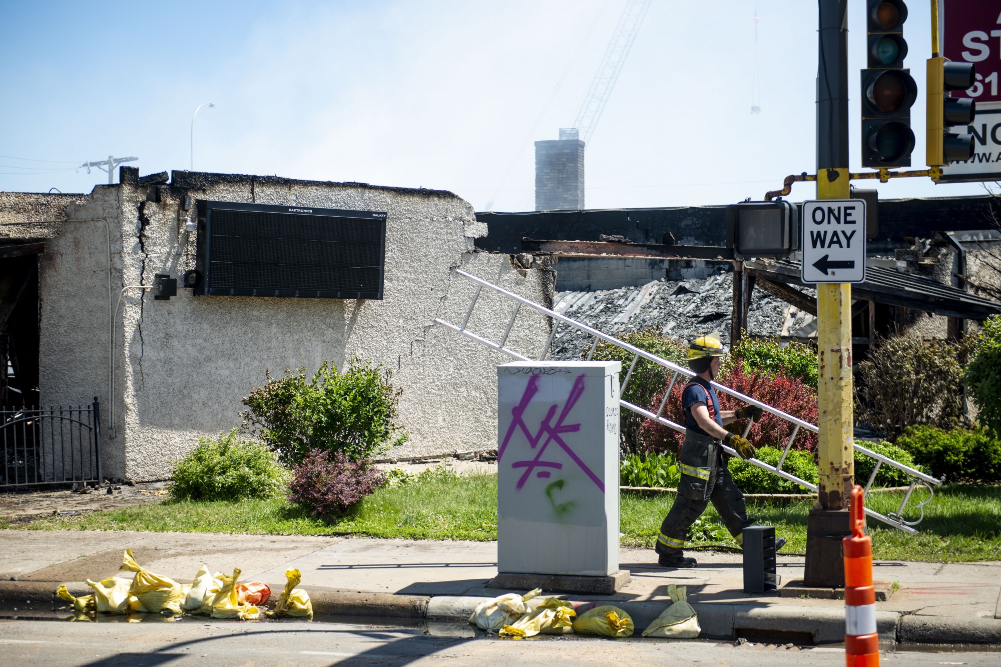 A firefighter carries a ladder near the Minneapolis 5th Police Precinct following another night of riots on Saturday, May 30.