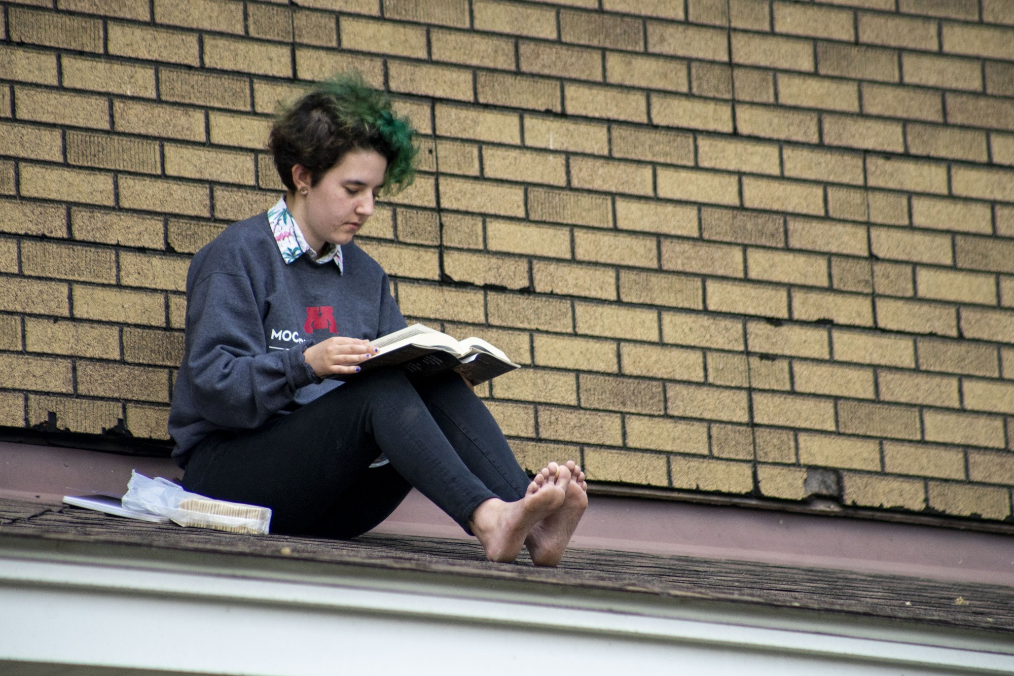 6:21 p.m.
Lilly Keefe-Powers reads a book on a Dinkytown rooftop. 