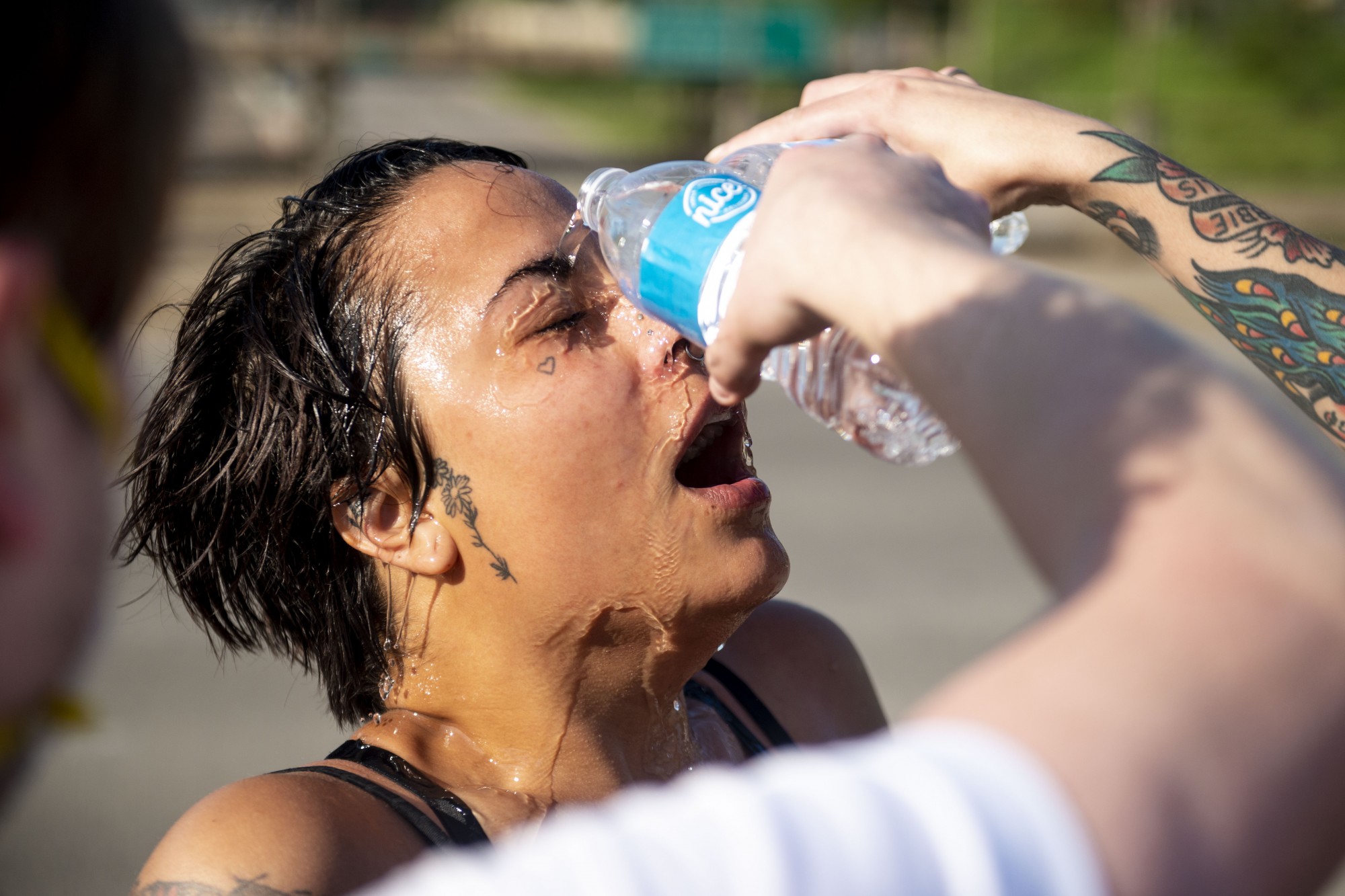 Two people pour water on the face of a protester who was tear-gassed at the intersection of I-35W and University Avenue on Sunday, May 31. 

